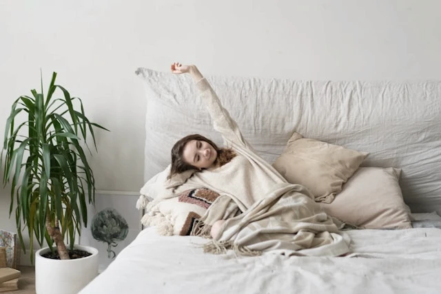 Woman stretching in bed in a bright bedroom