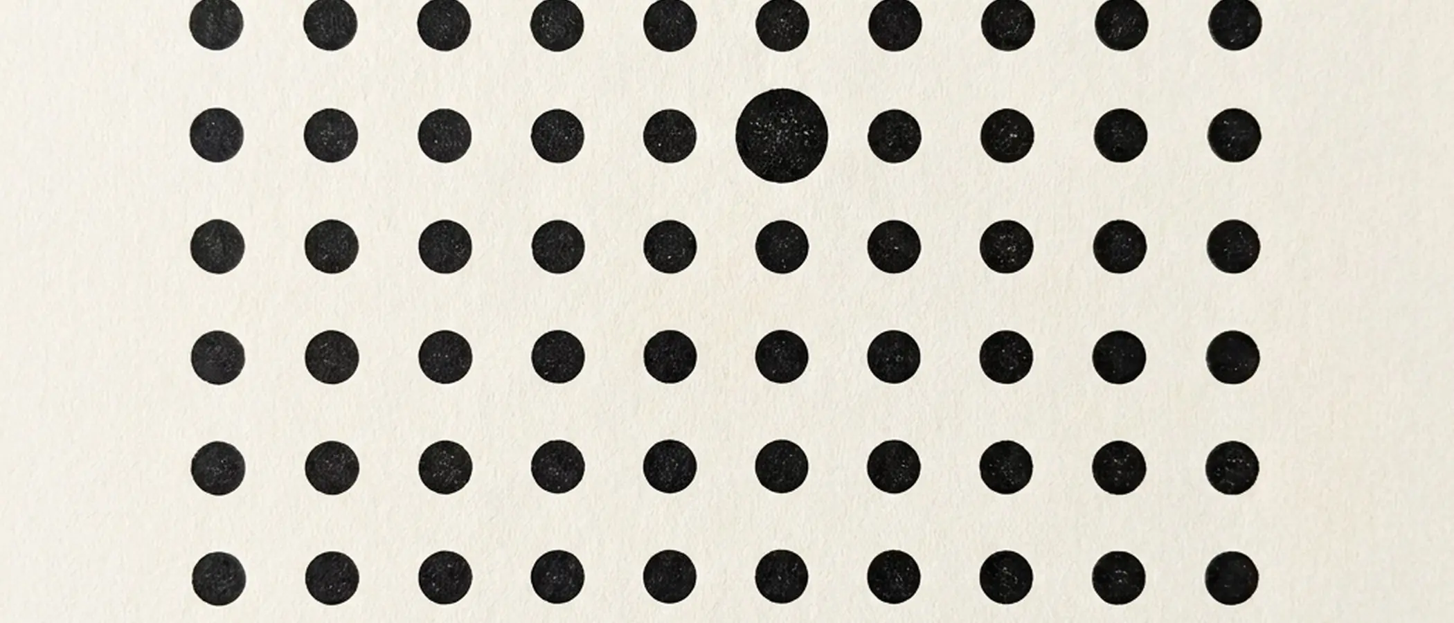 Grid of black dots with one larger, textured dot.