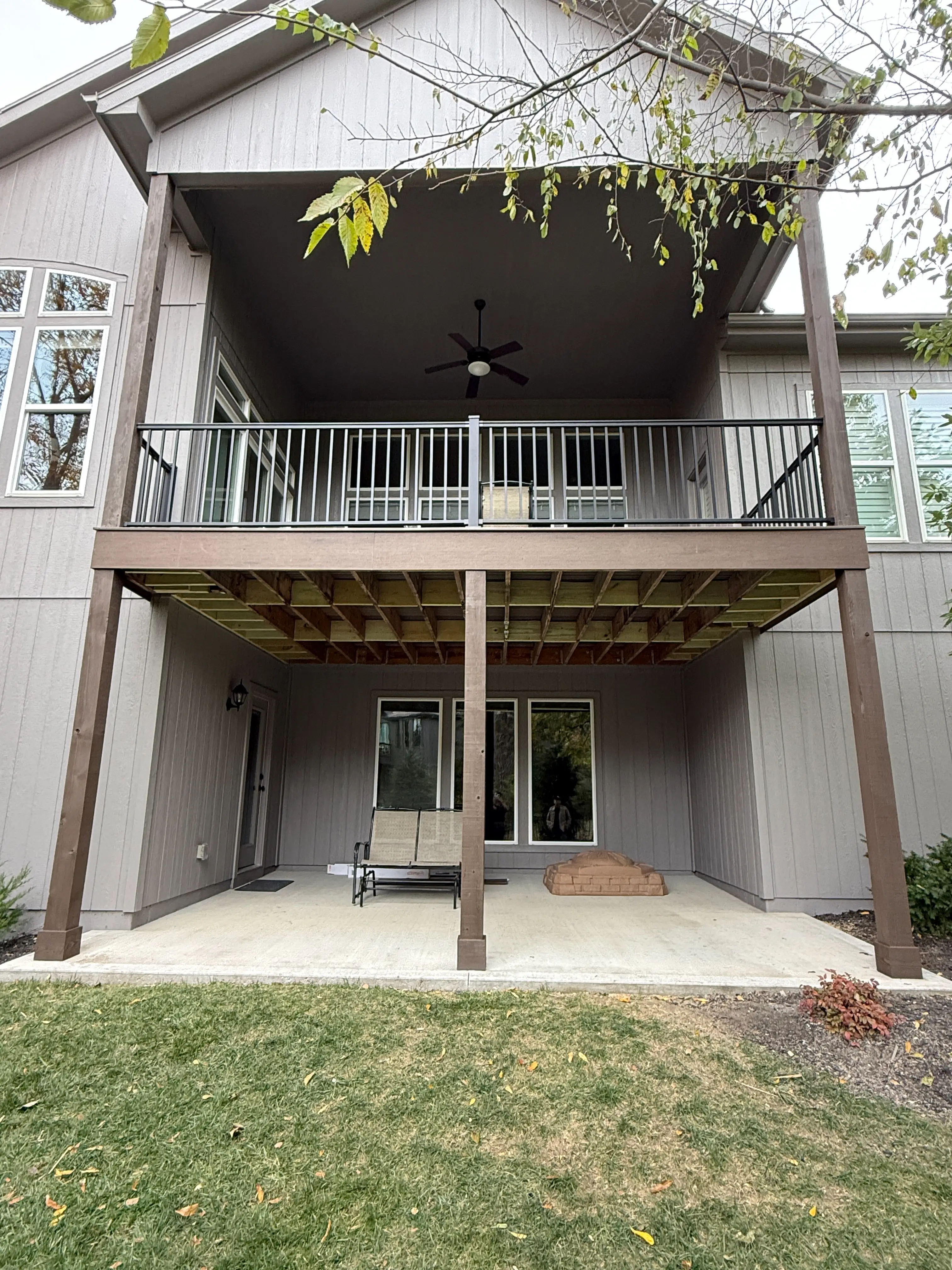 An image looking up at a newly installed deck above a patio.
