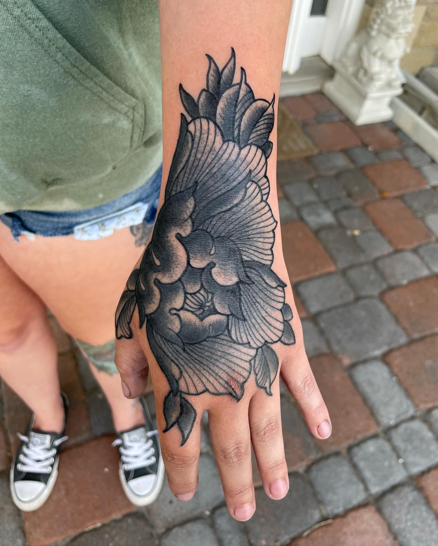 Black-and-grey owl tattoo on a hand