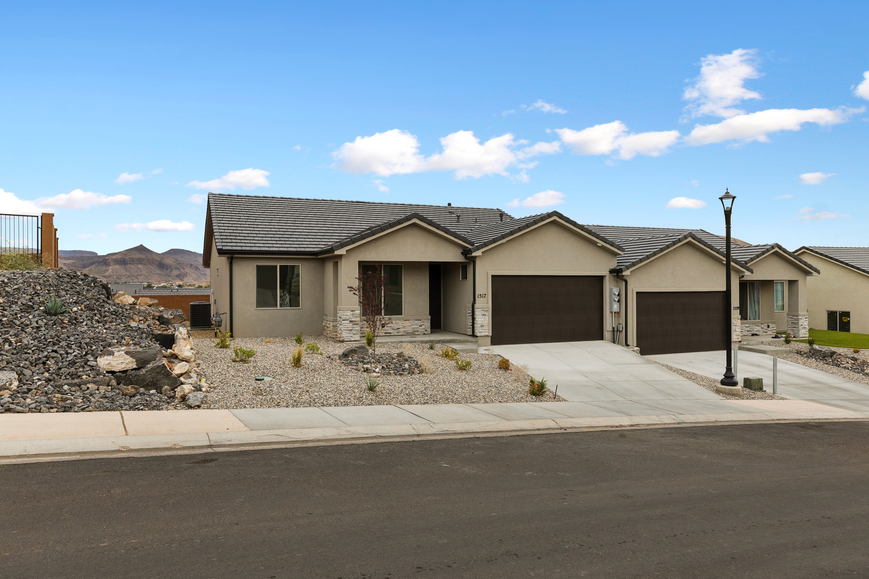 Front exterior of The High Desert Home in Hurricane Utah with two-car garage under bright daylight.