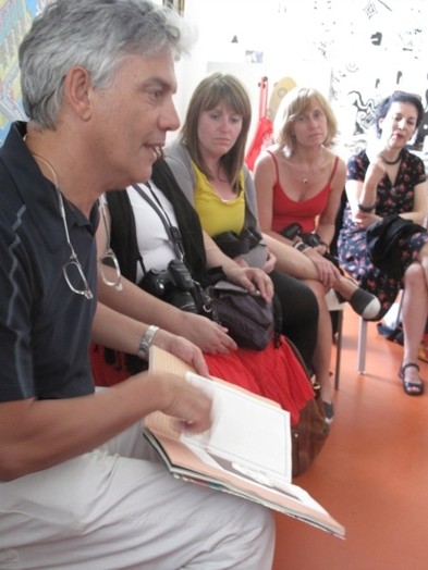 A photo of a person showing a drawing to a group of students.