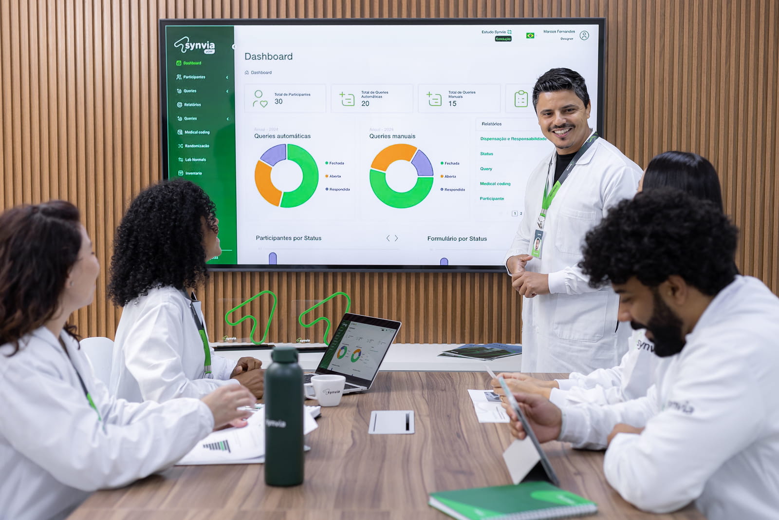 Equipe da Synvia conduzindo reunião estratégica de start-up para estudo clínico com análise de indicadores em dashboard