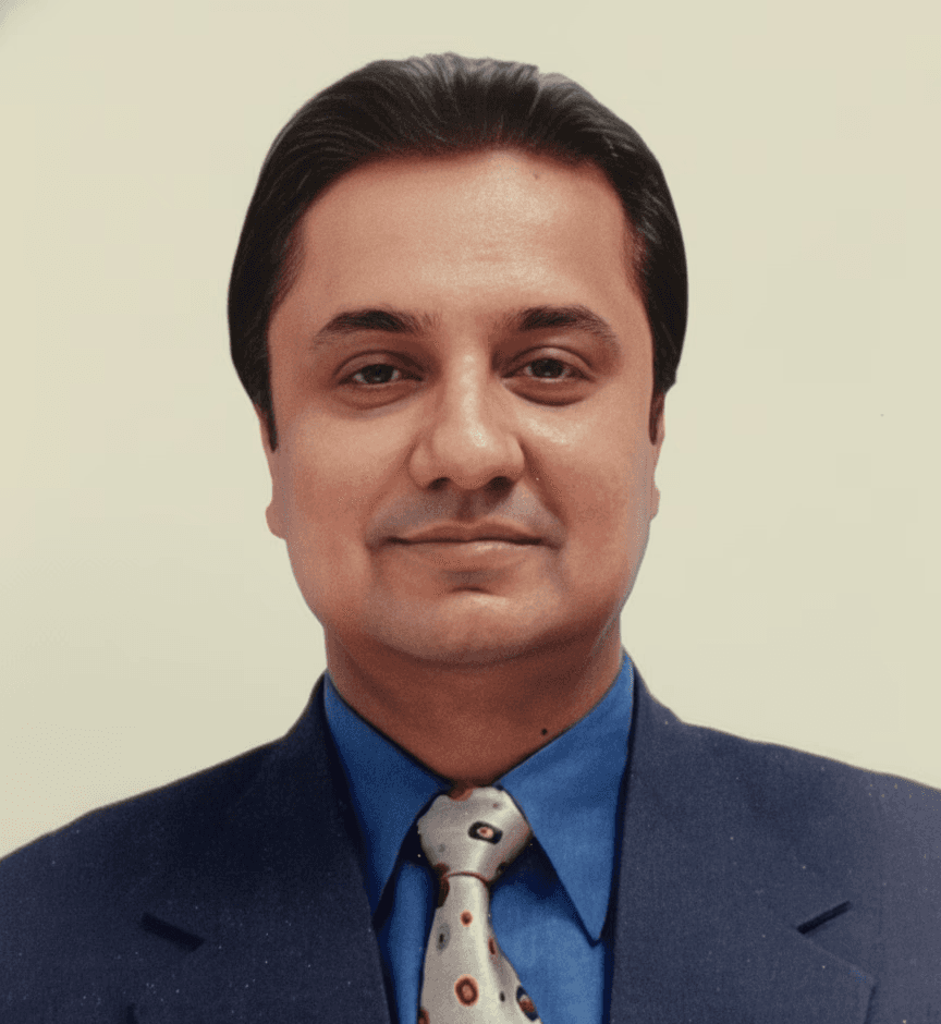 A businesswoman sitting at her desk, smiling and looking at the camera.