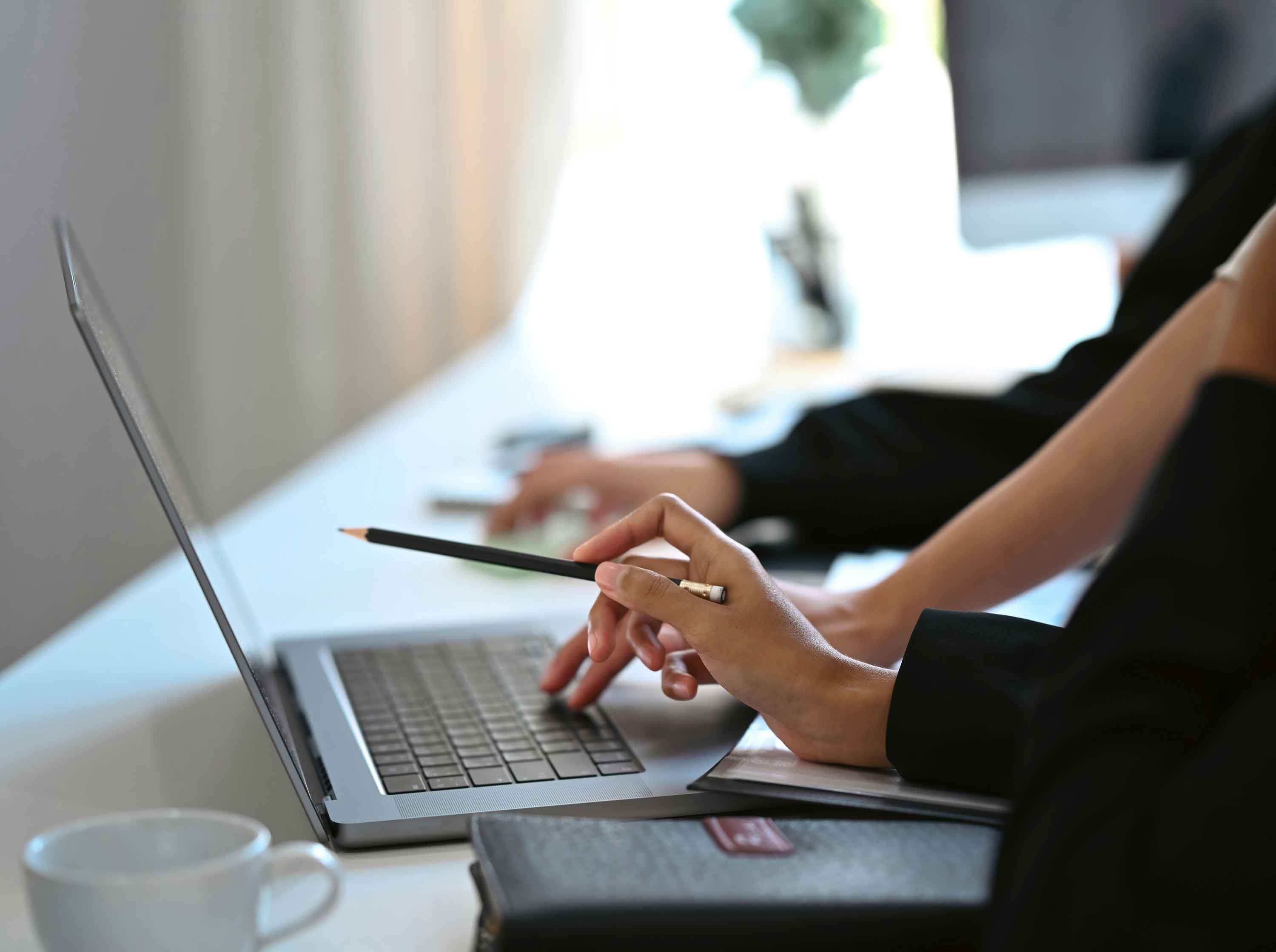 Two real estate industry professionals using laptop to improve economic outcomes