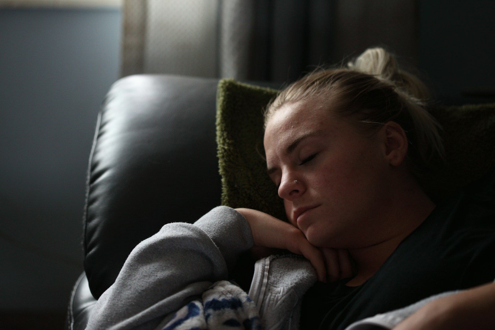 A tired woman resting on a couch, reflecting how diet, stress, sleep, and illness can throw the gut microbiome out of balance