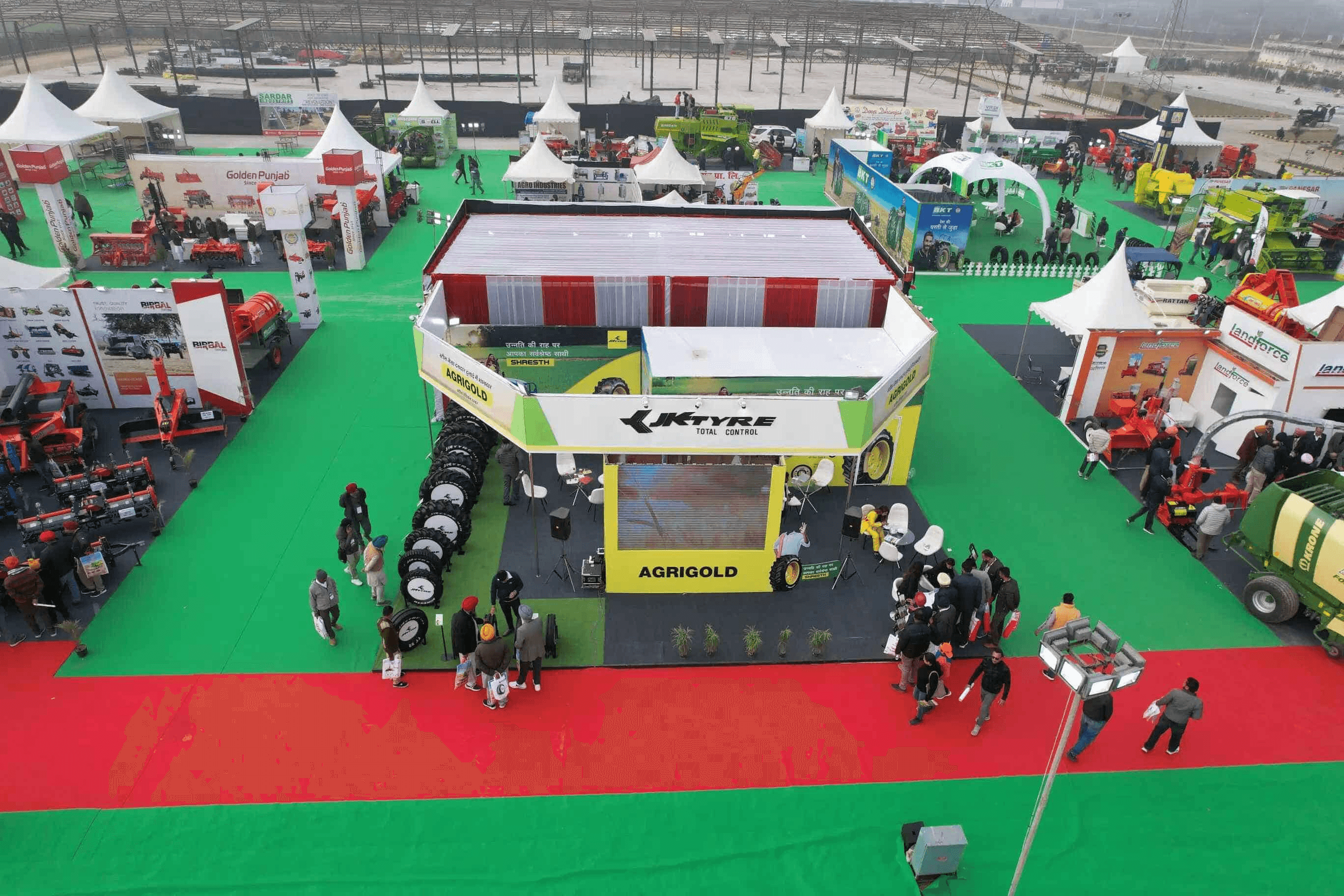  Busy expo floor at Agri Agro Grand Expo with farmers in traditional attire, agri-business professionals, and officials networking among stalls displaying seeds, fertilizers, and machinery, highlighting expert collaboration and investment opportunities in Indian agriculture.