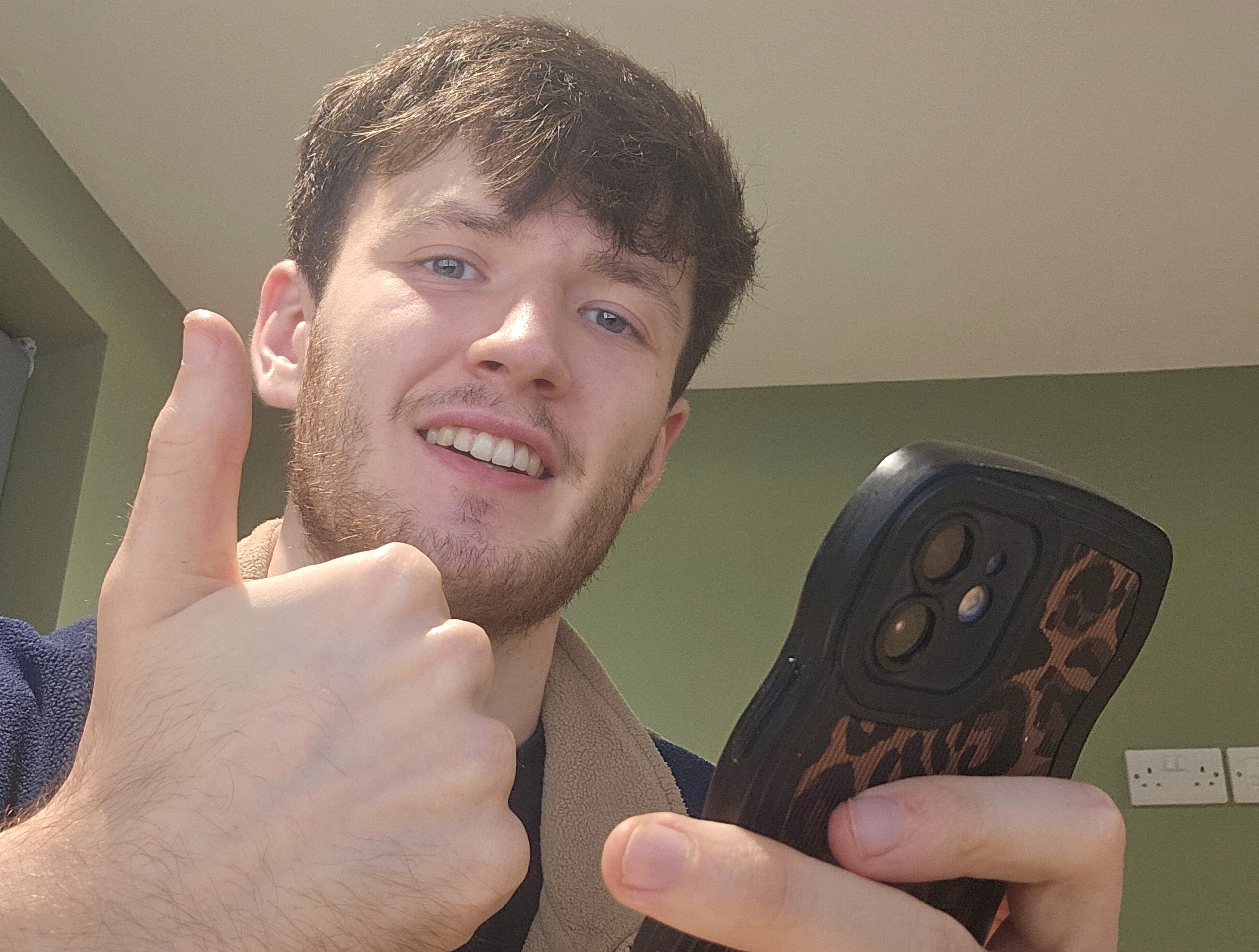 Tim monteverde giving thumbs up looking at phone with beta of MOTRA app