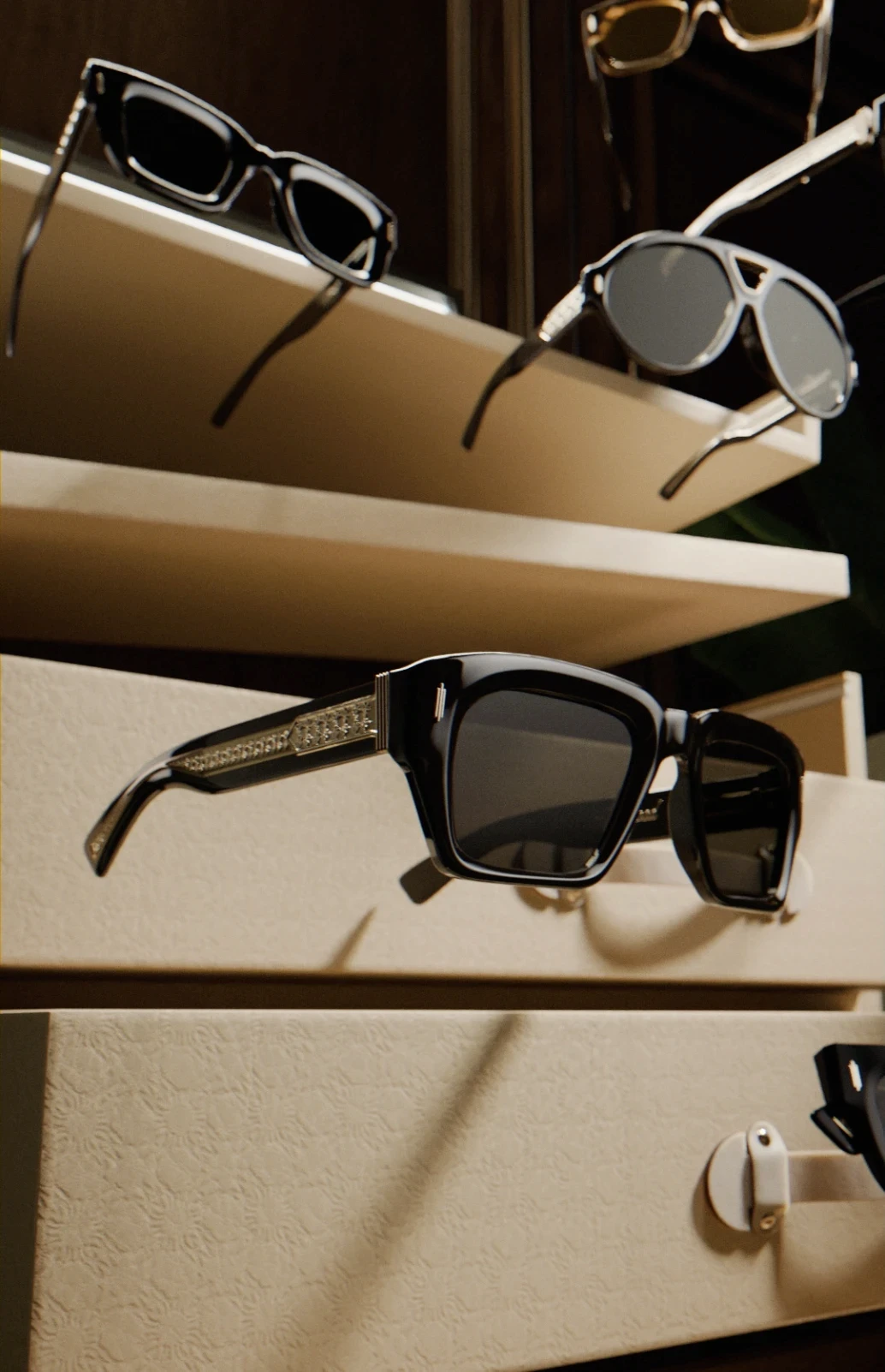A macro product shot showcases black, thick-rimmed sunglasses on a tiered, minimalist display