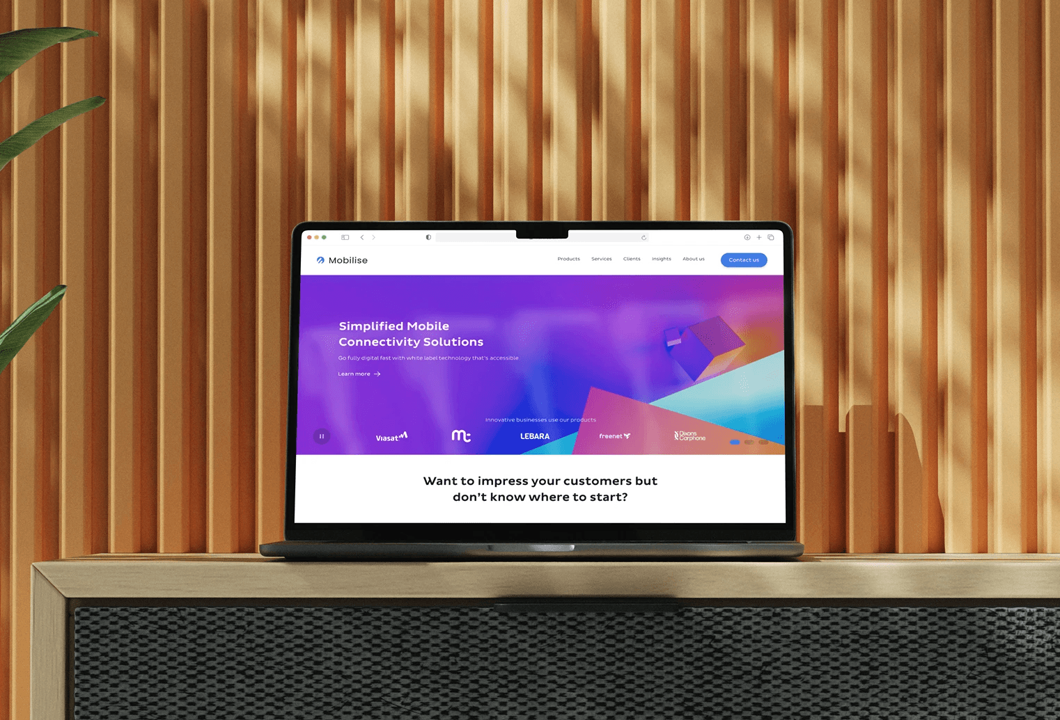 Laptop on a wooden desk displaying the updated Mobilise website with the new brand visuals.