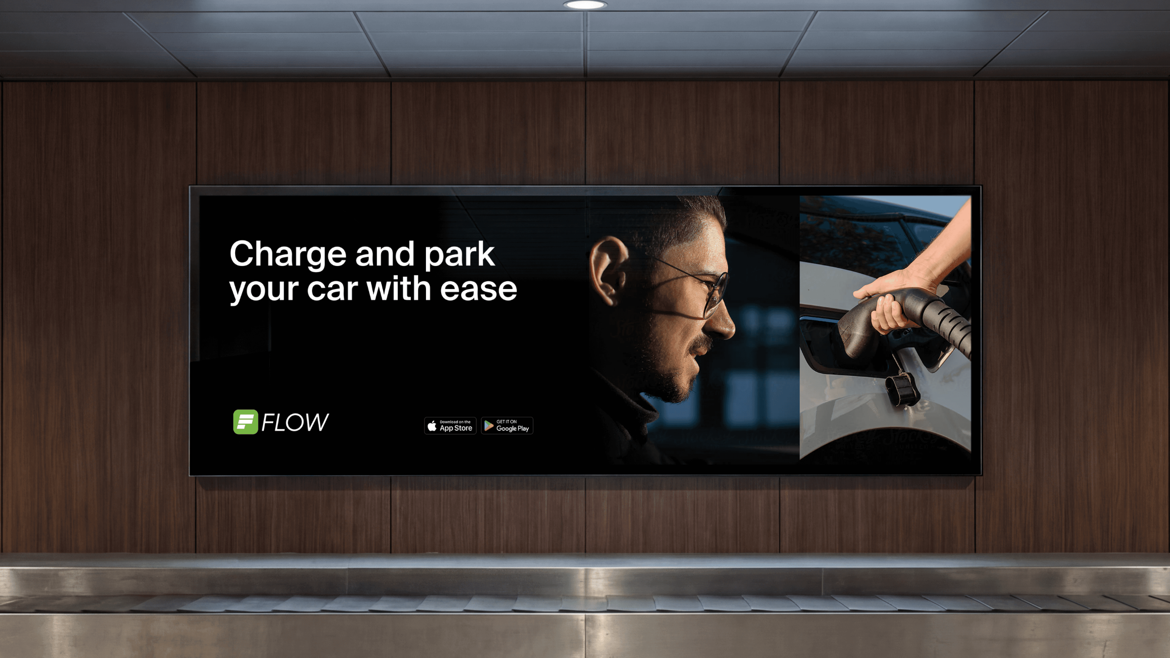 A large-scale digital billboard mockup in a transit hub featuring the APCOA Flow "Charge and park" campaign