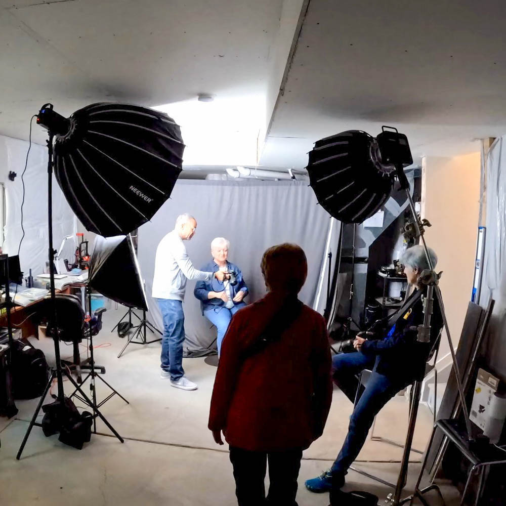 Photography studio setup with softboxes and a group preparing for a portrait session.