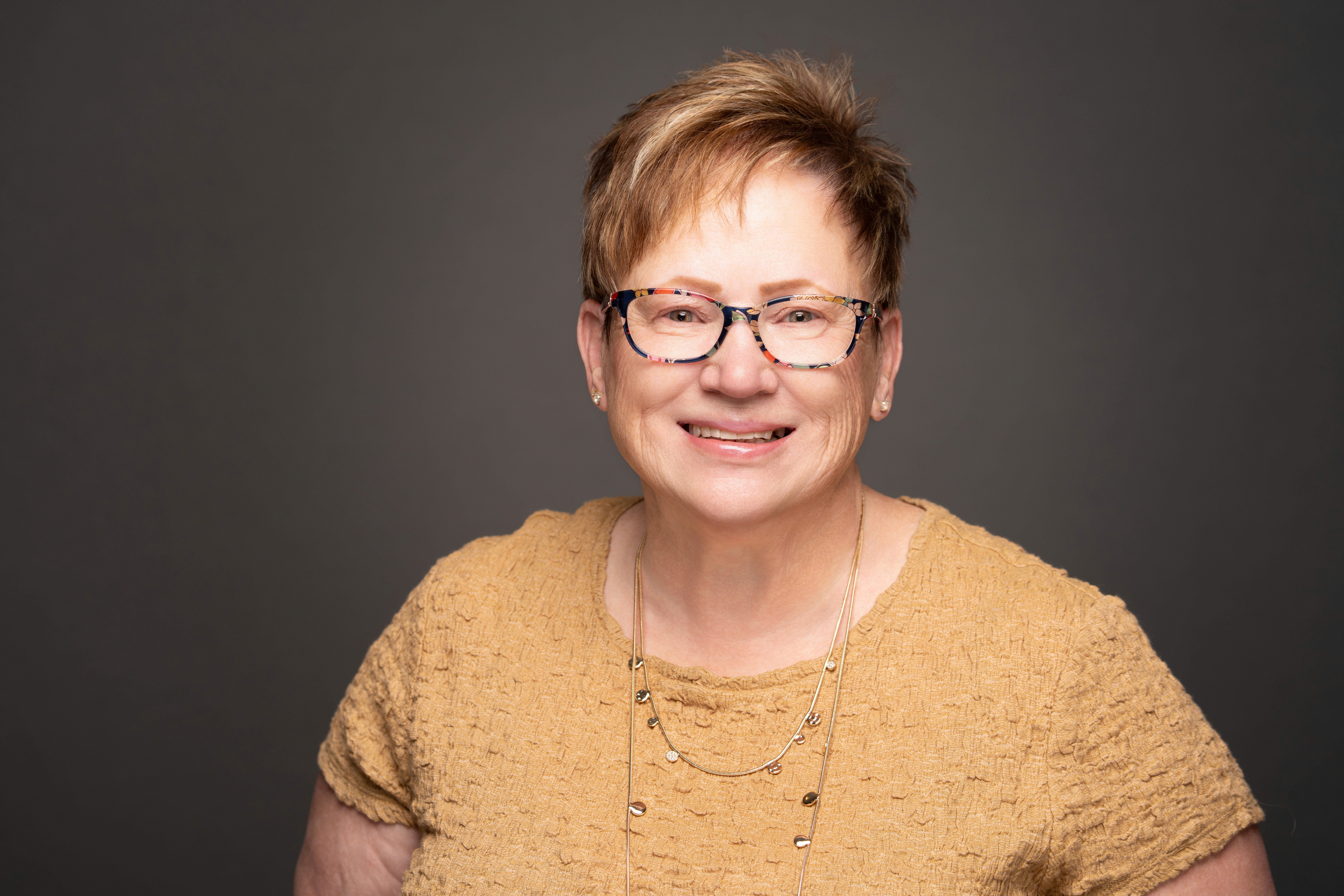 Linda in a yellow shirt, headshot