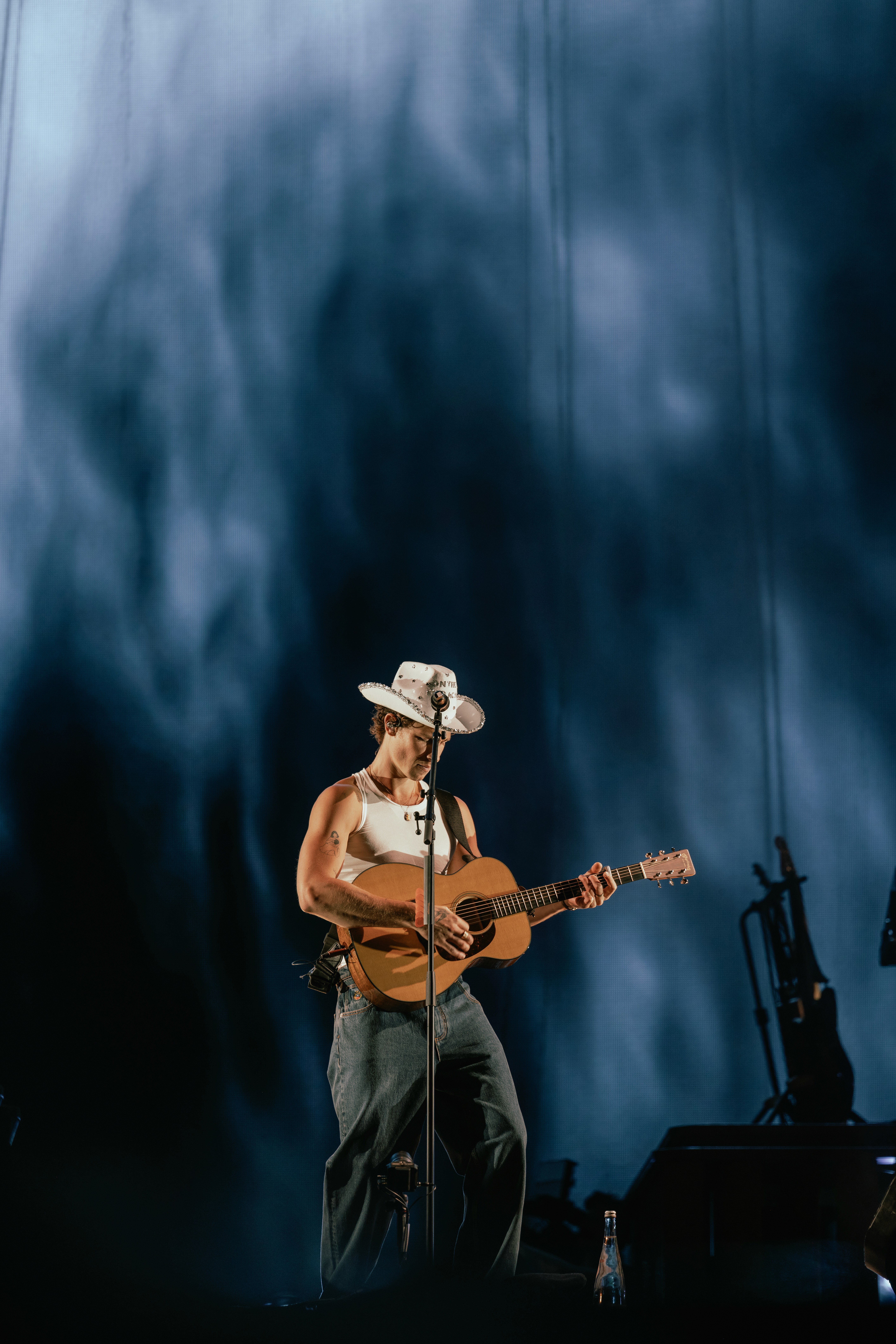 Stylish individual with platinum blonde hair, sunglasses, and leather outfit