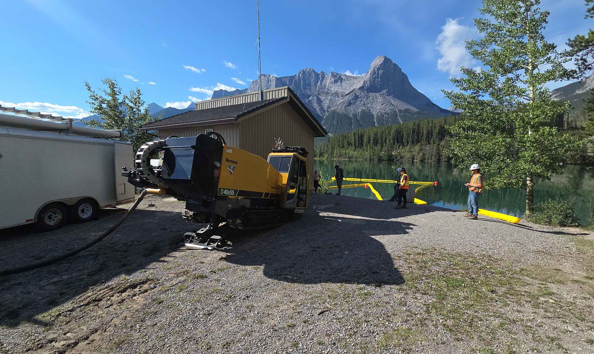Directional drilling for snowmaking pipeline upgrade at Canmore Nordic Centre amid Rocky Mountains.