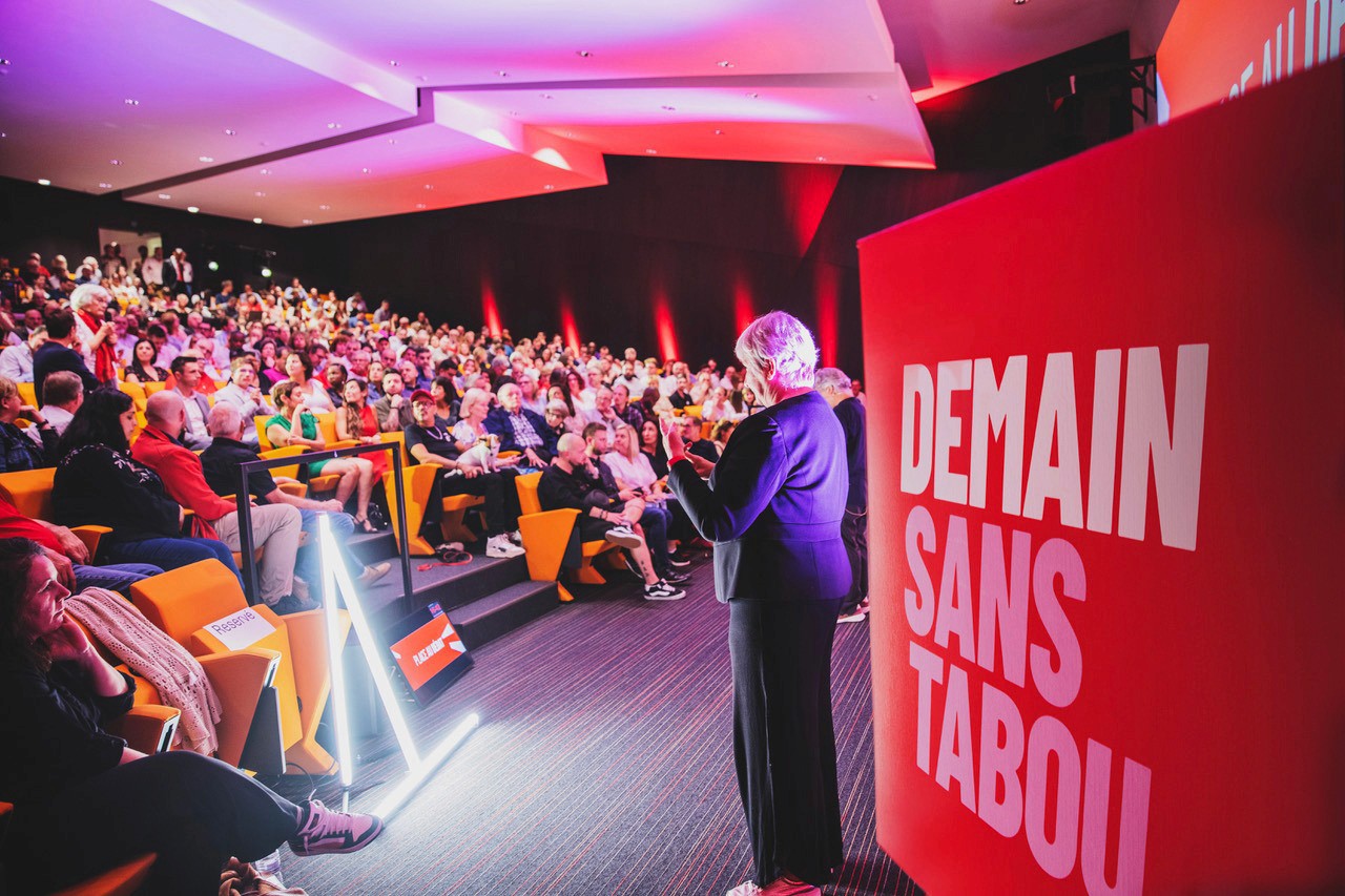 Modern home office setup with a monitor, ergonomic chair, keyboard, and indoor plants near a window with blinds.