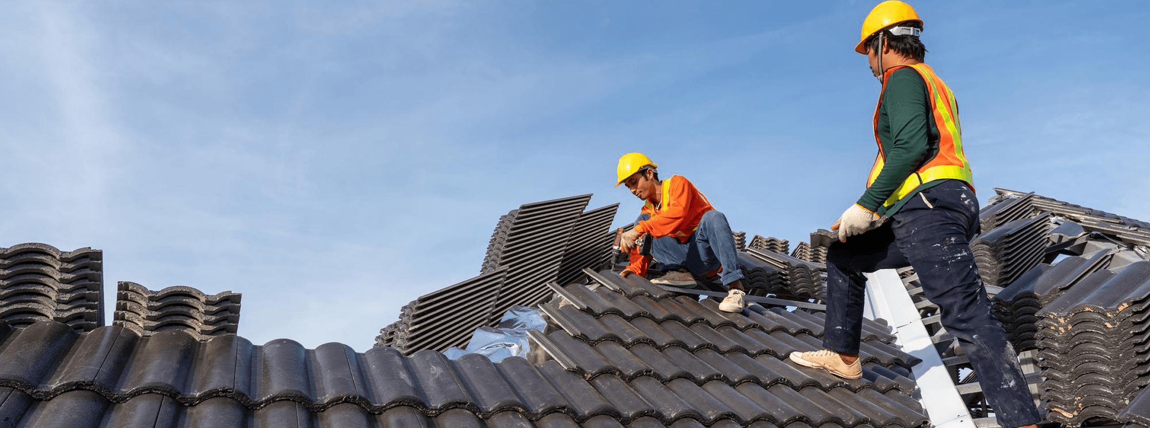 a man in a yellow shirt is working on a roof