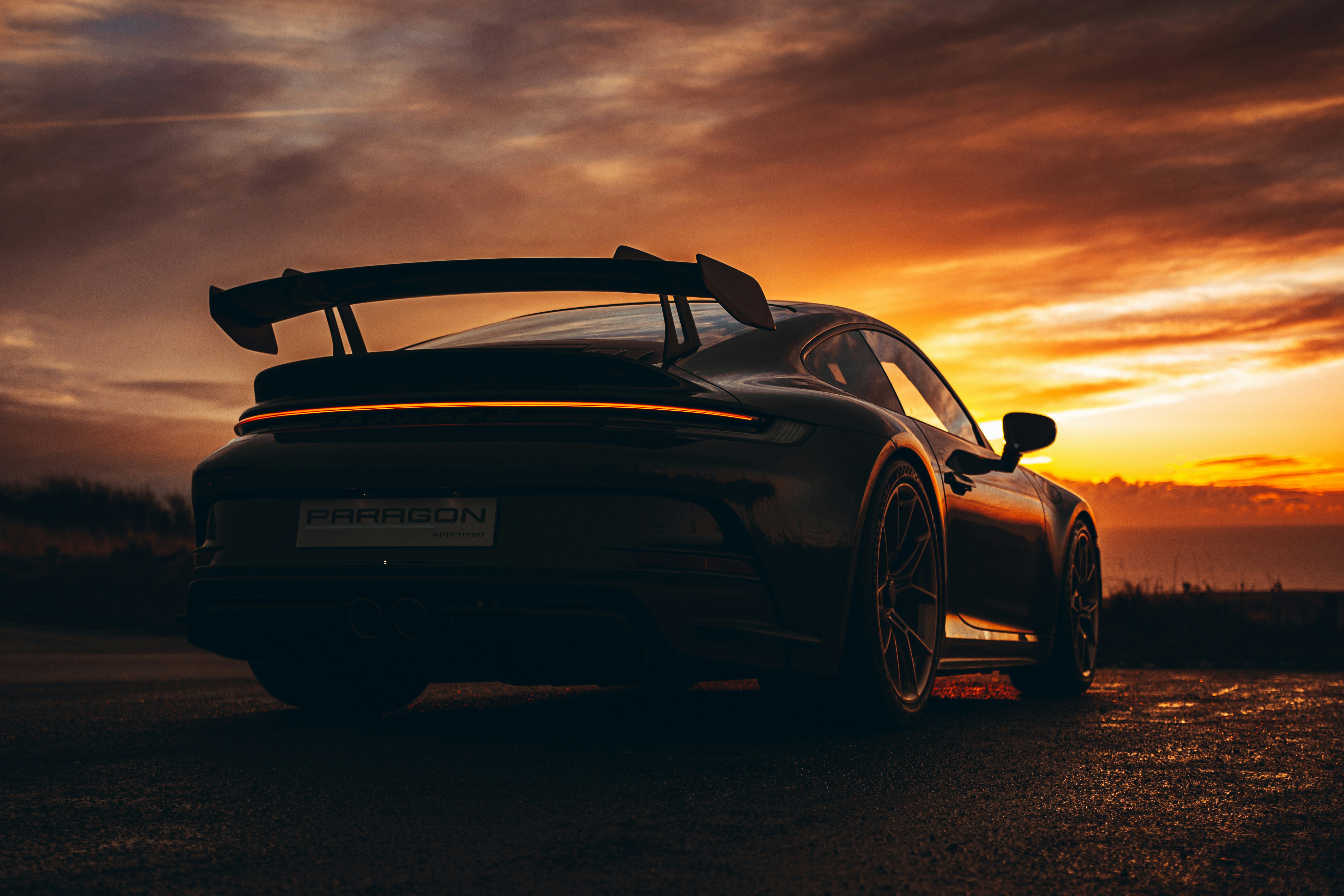 A car parked on the side of the road at sunset