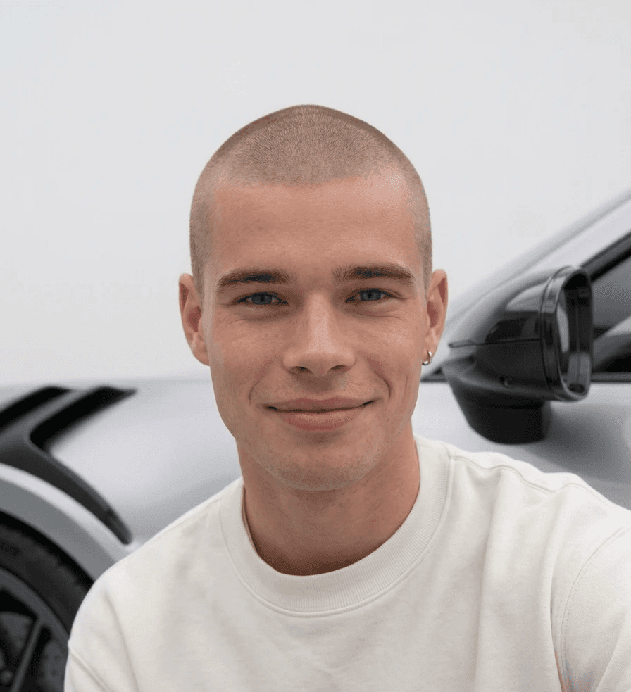 Young man posing in front of his Porsche 911