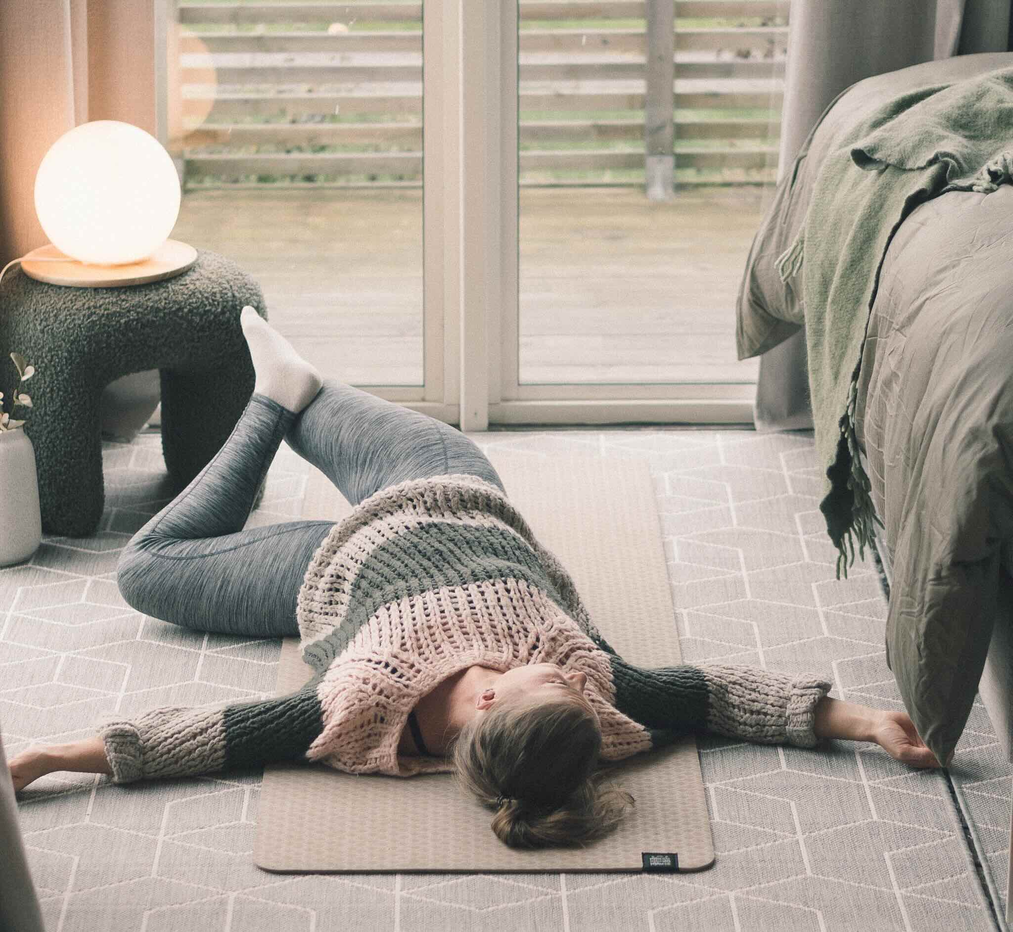 A baseball team in yellow jerseys huddles together, raising their maroon caps in the air.