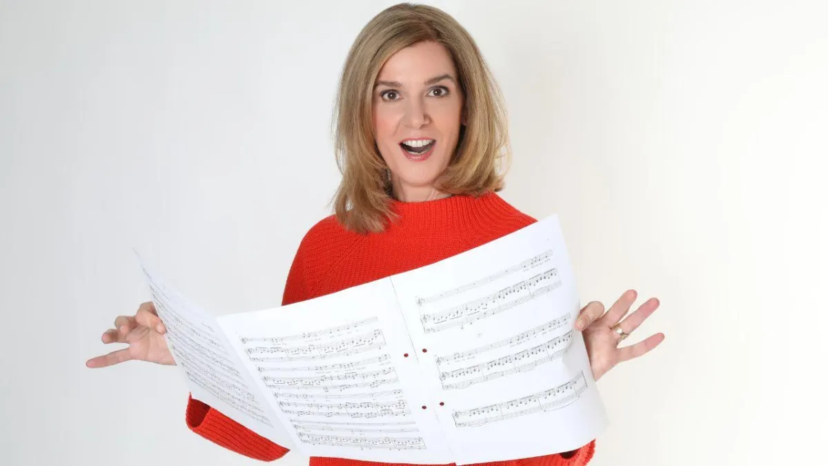 Danielle Zuber hält professionelle Notenblätter in den Händen und präsentiert die im Kurs enthaltenen Playbacks und Übungsmaterialien.