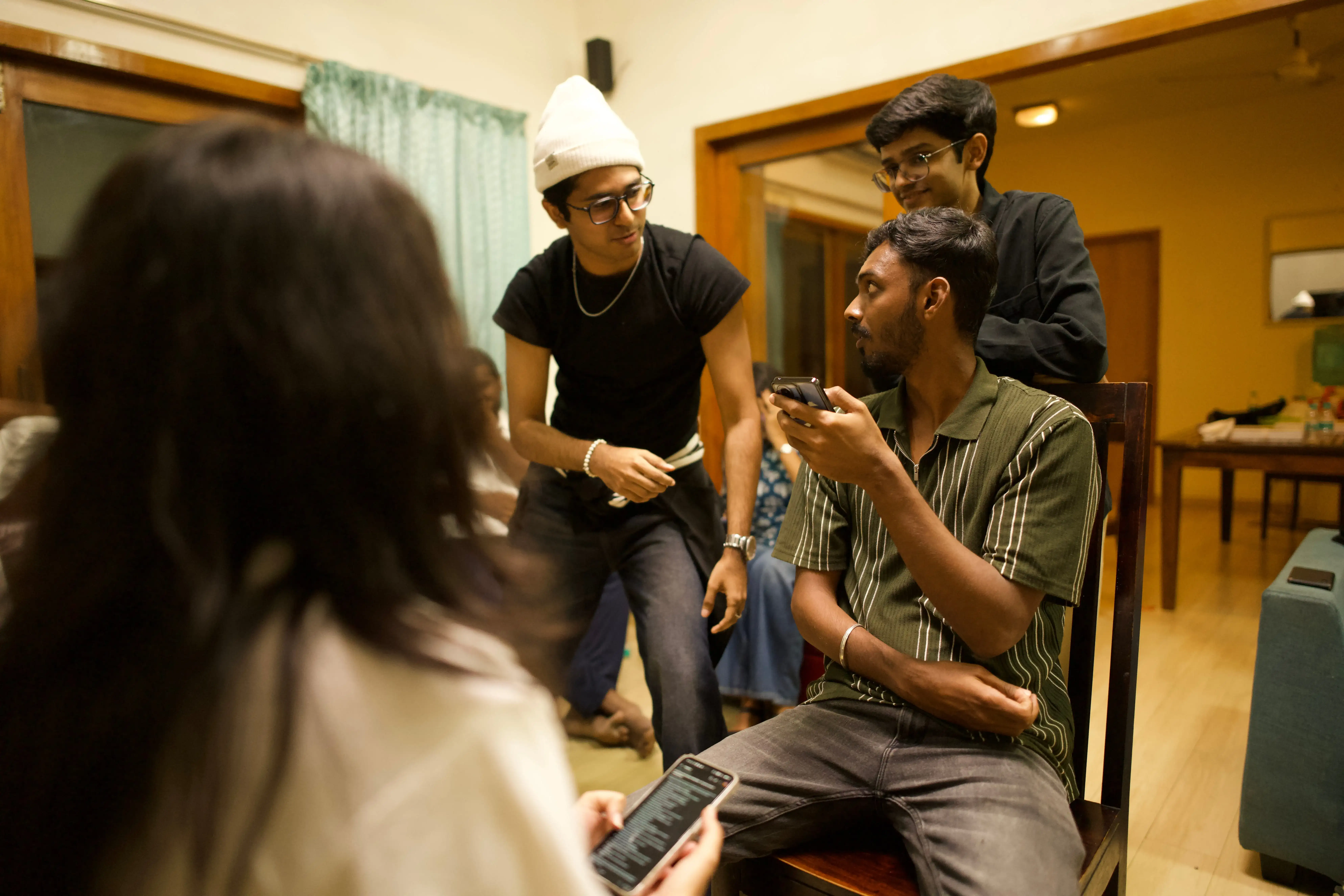 Team members gathered indoors during a casual discussion and bonding session at a Maayasthra event.