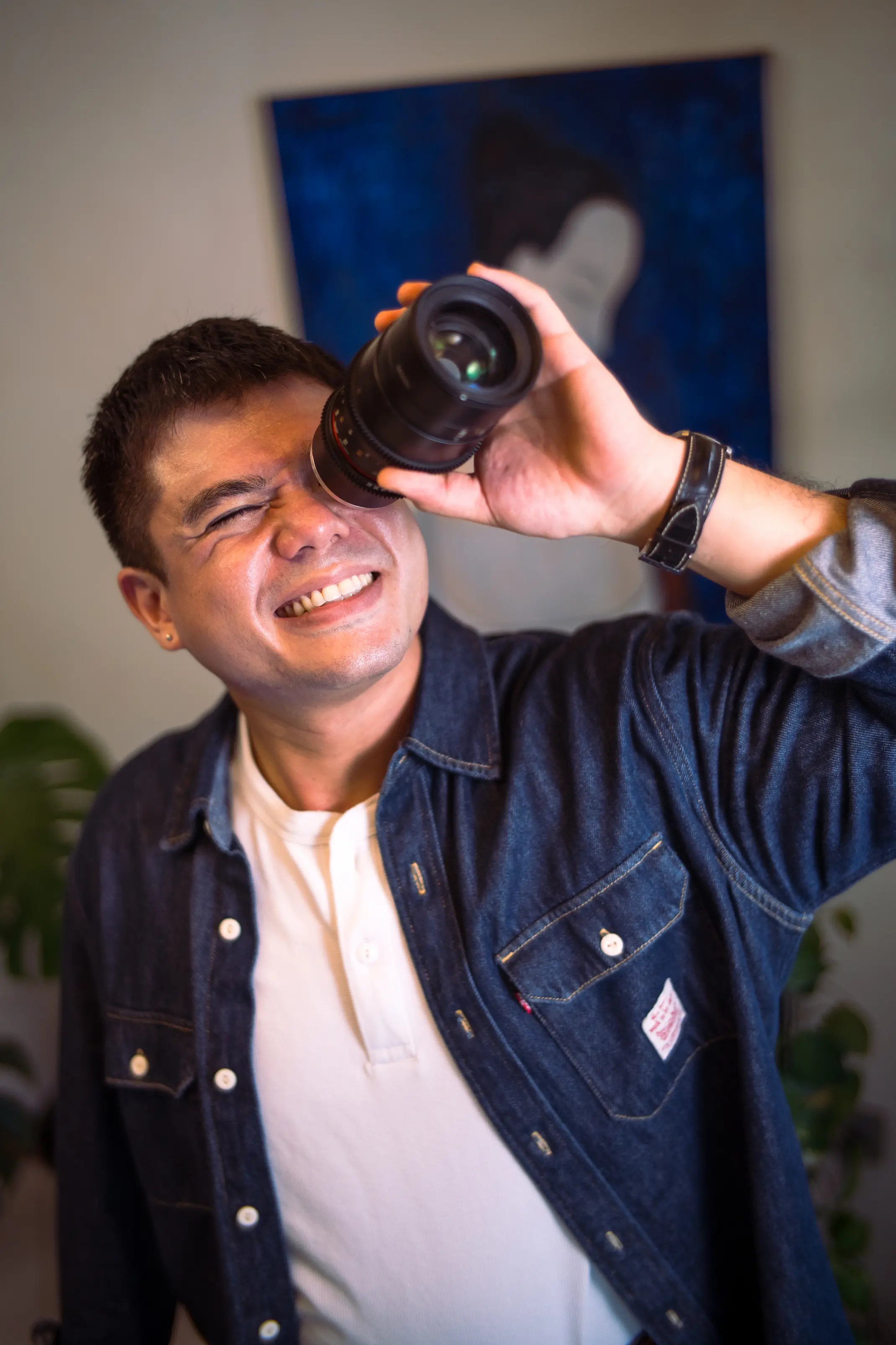 Portrait of a laughing person with curly hair wearing a white shirt