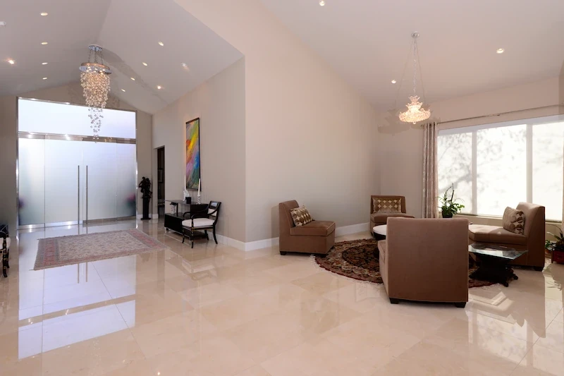 Spacious Harbor Ridge Transitional Remodel living room with high ceilings and polished marble floor.