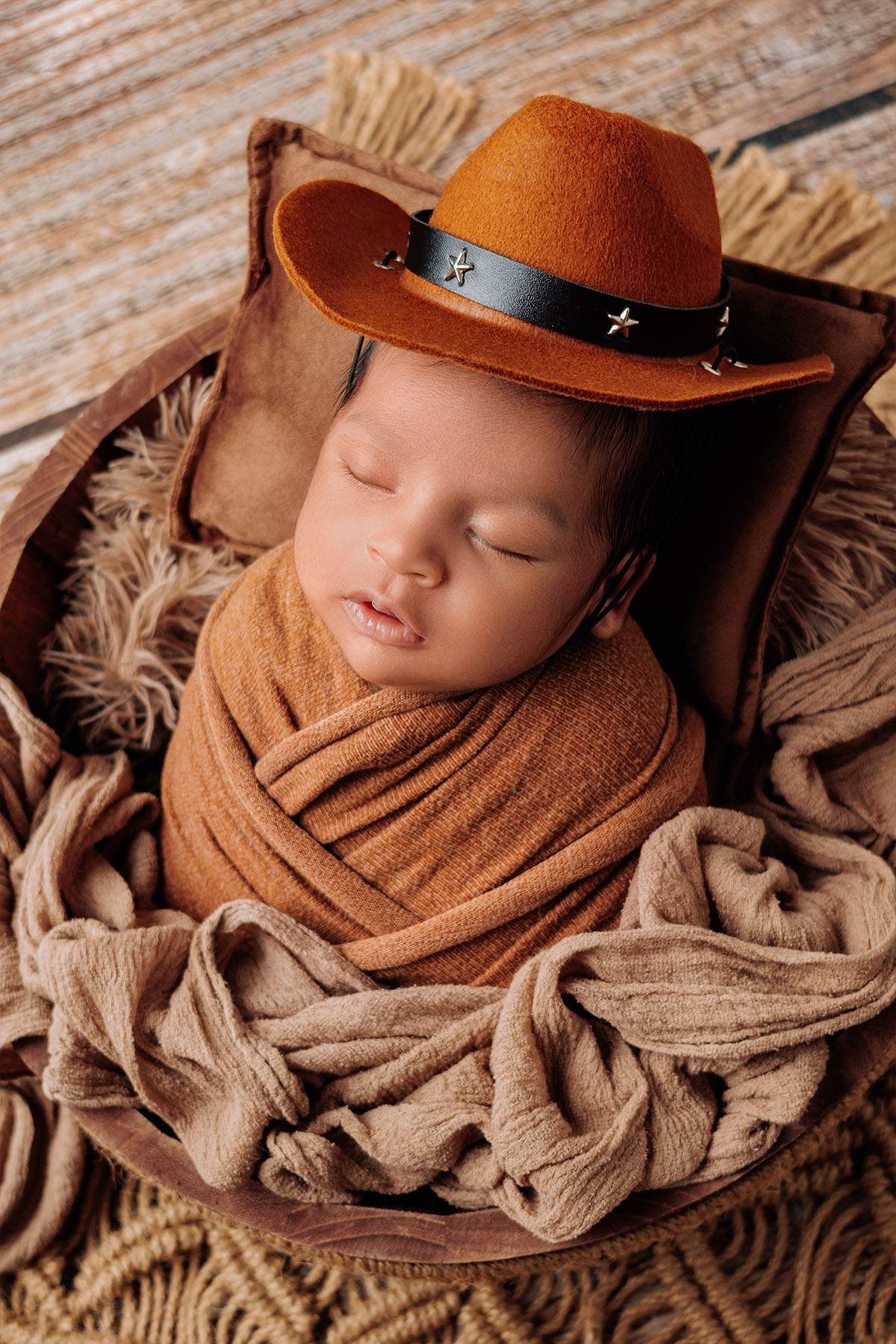 Cozy newborn photography with baby wrapped in neutral tones and soft light.