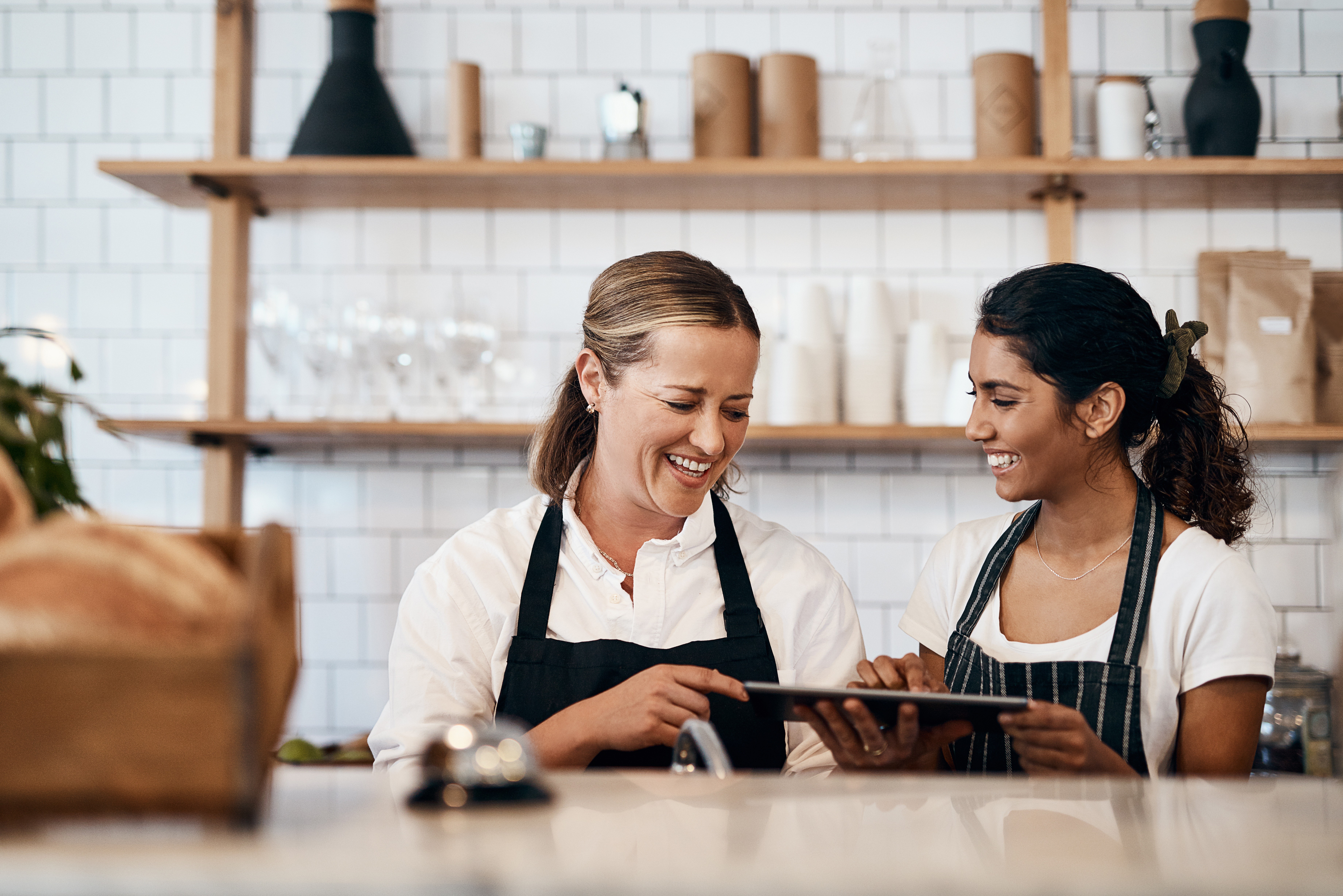 cafe manager talking with barista in cafe