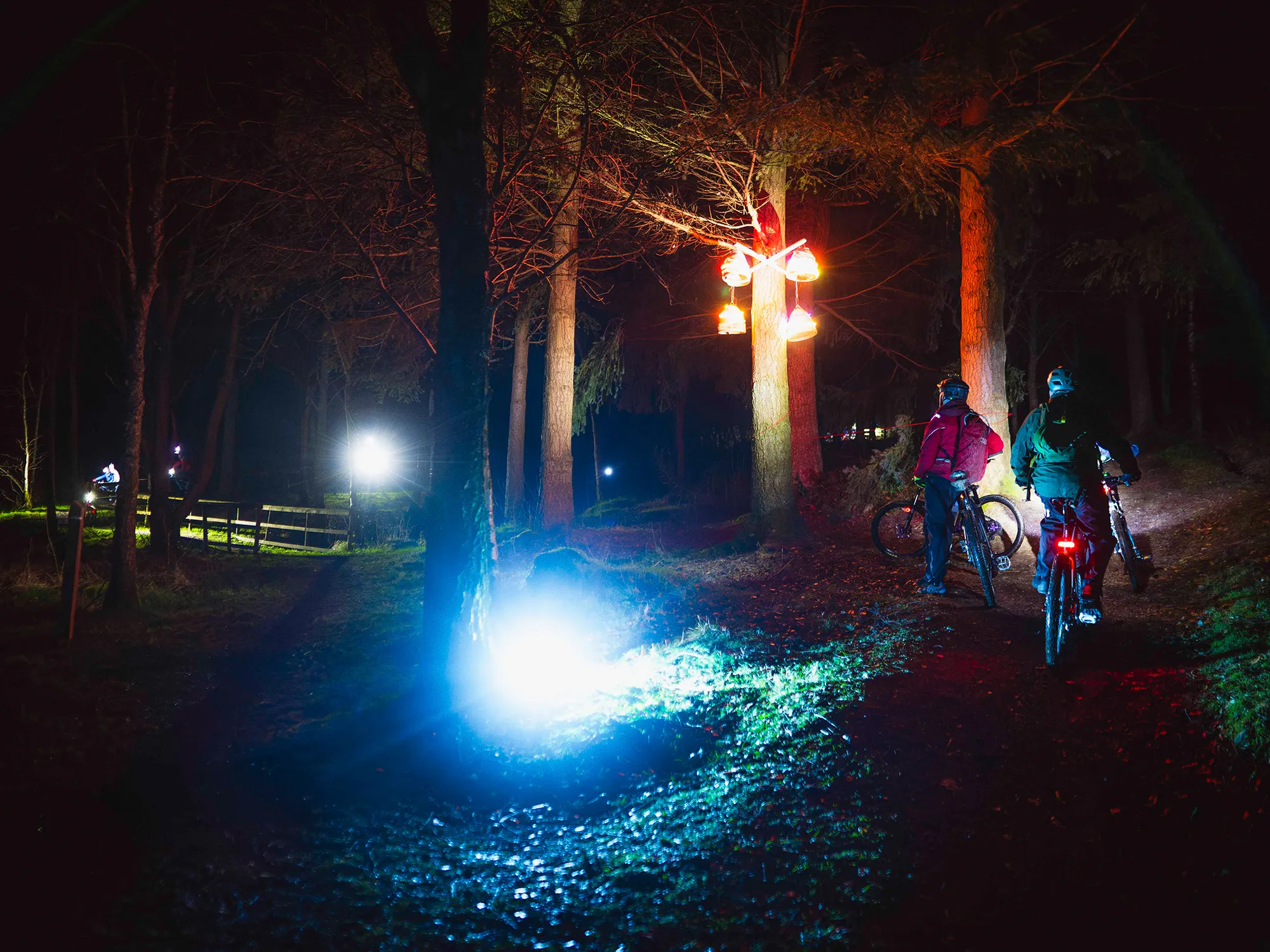 A family riding their bikes at the Light Up The Trails event at Glentress Forest