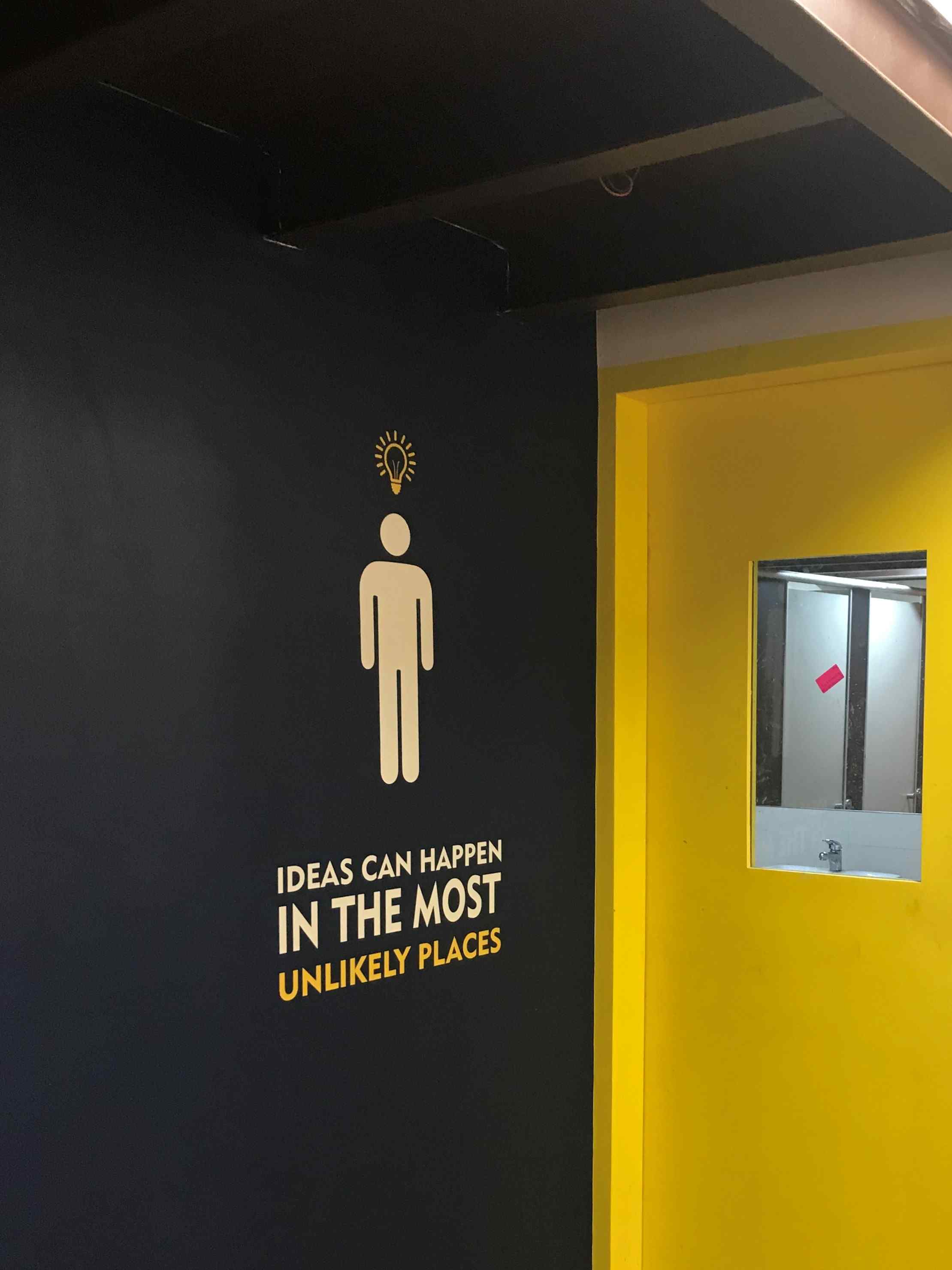 Nature-inspired preschool entrance with sculptural tree partitions and suspended green leaf ceiling panels.