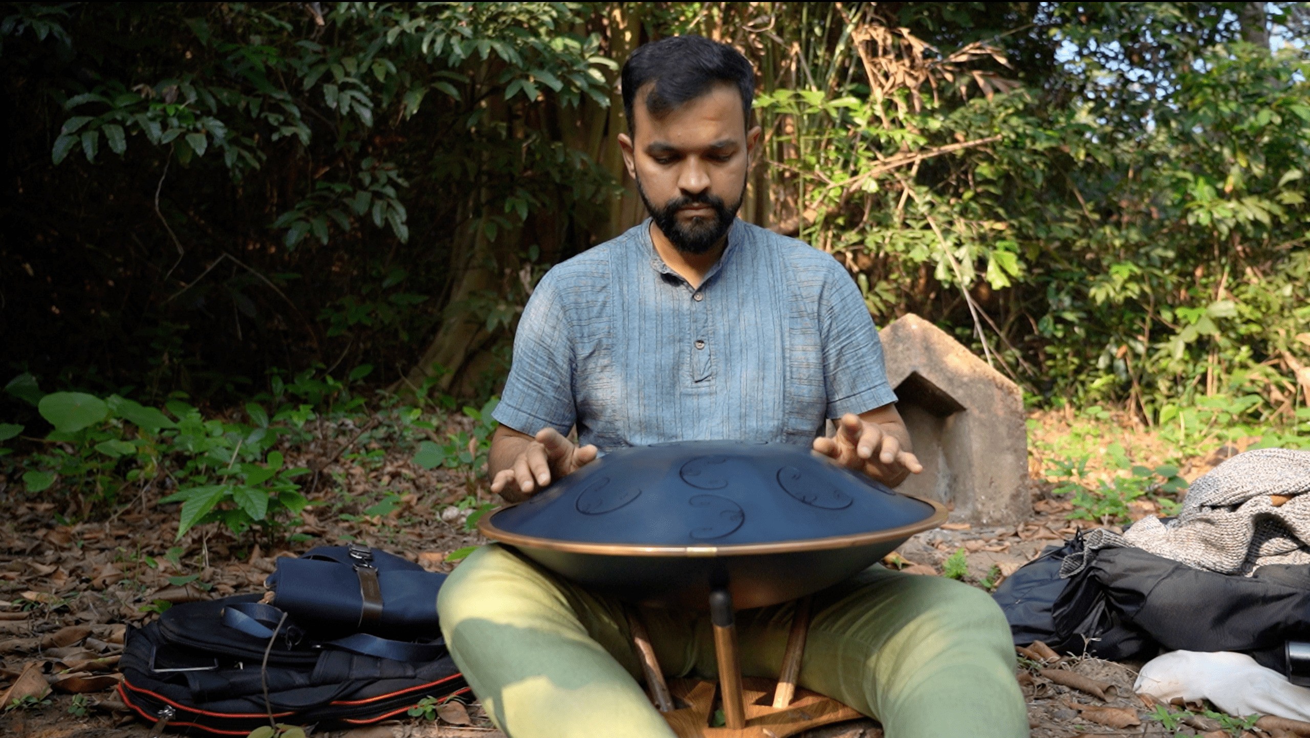 a man playing handpan instrument in nature