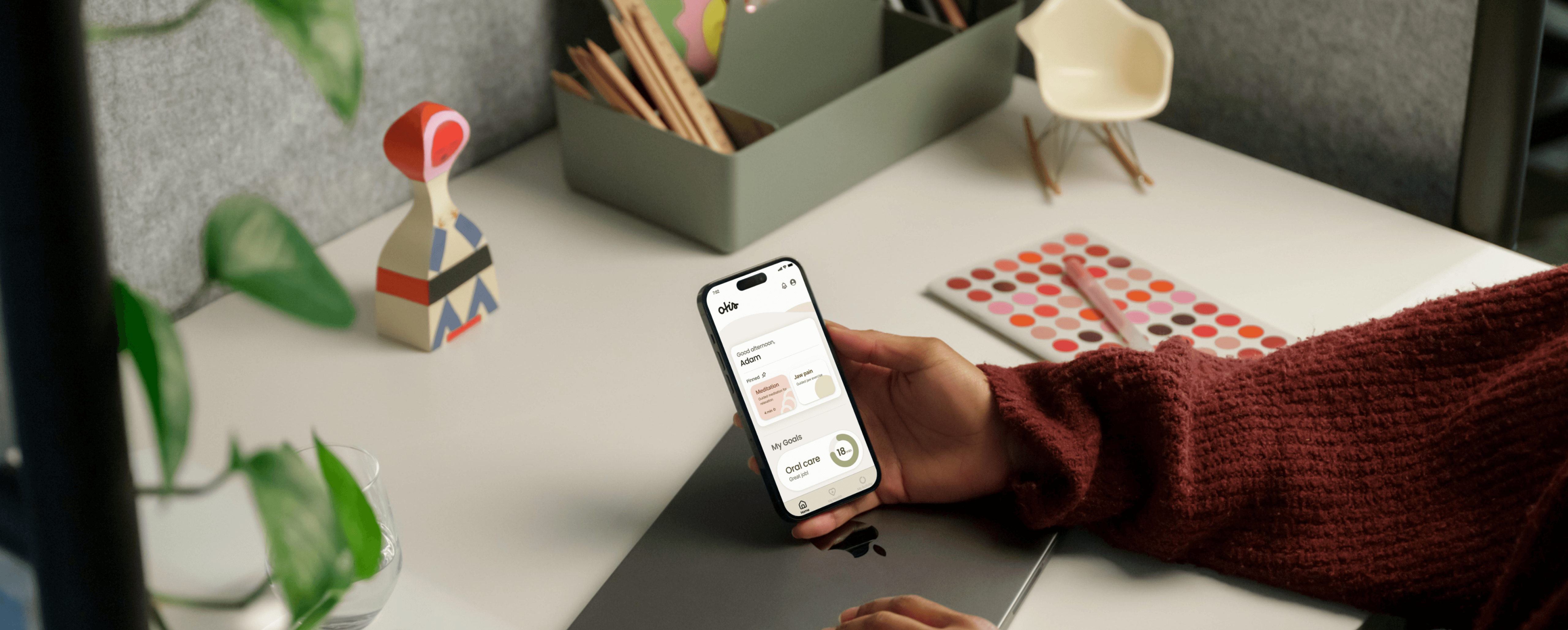 Person holding a smartphone with a wellness app, designed by Brash, on screen.