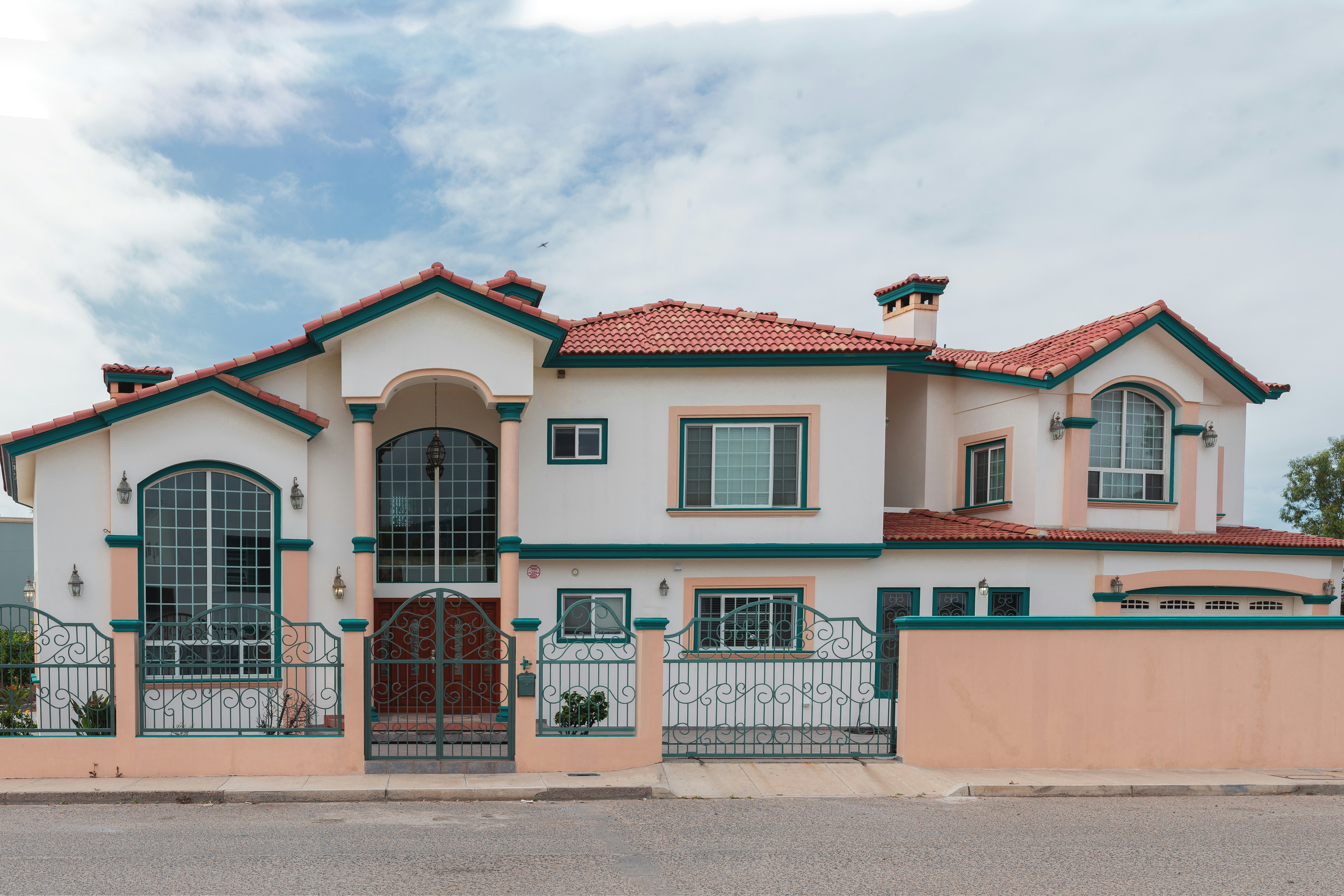 Hand holding an open book beside a laptop and coffee cup.
