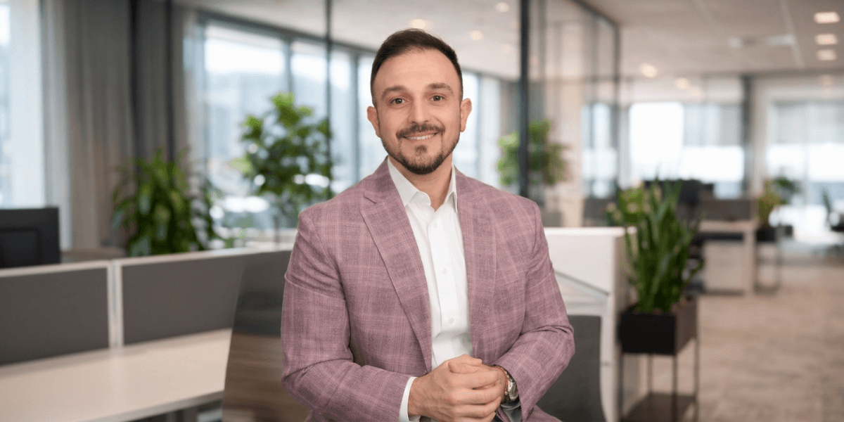 Adam Shoar, founder of DidYouKnow.Pro, seated in modern office promoting automotive finance training platform.