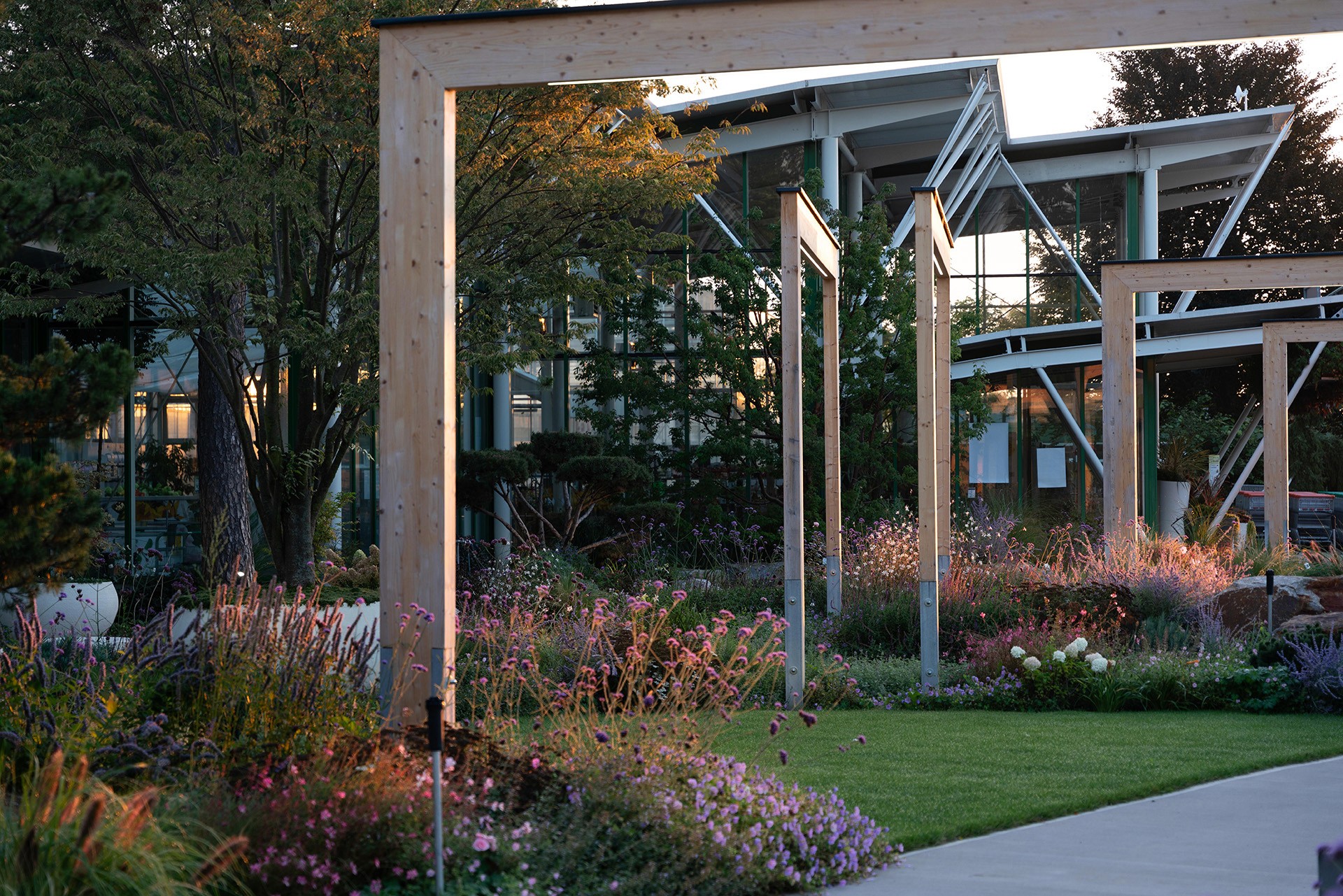 Moderner Schaugarten mit Holzrahmen, üppigen Pflanzflächen und zeitgemäßer Gartenarchitektur.
