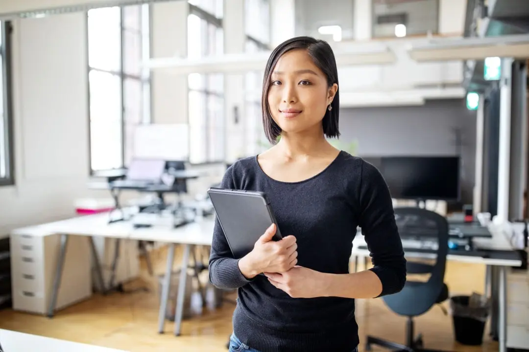 Woman holding a tablet in an open-plan office
