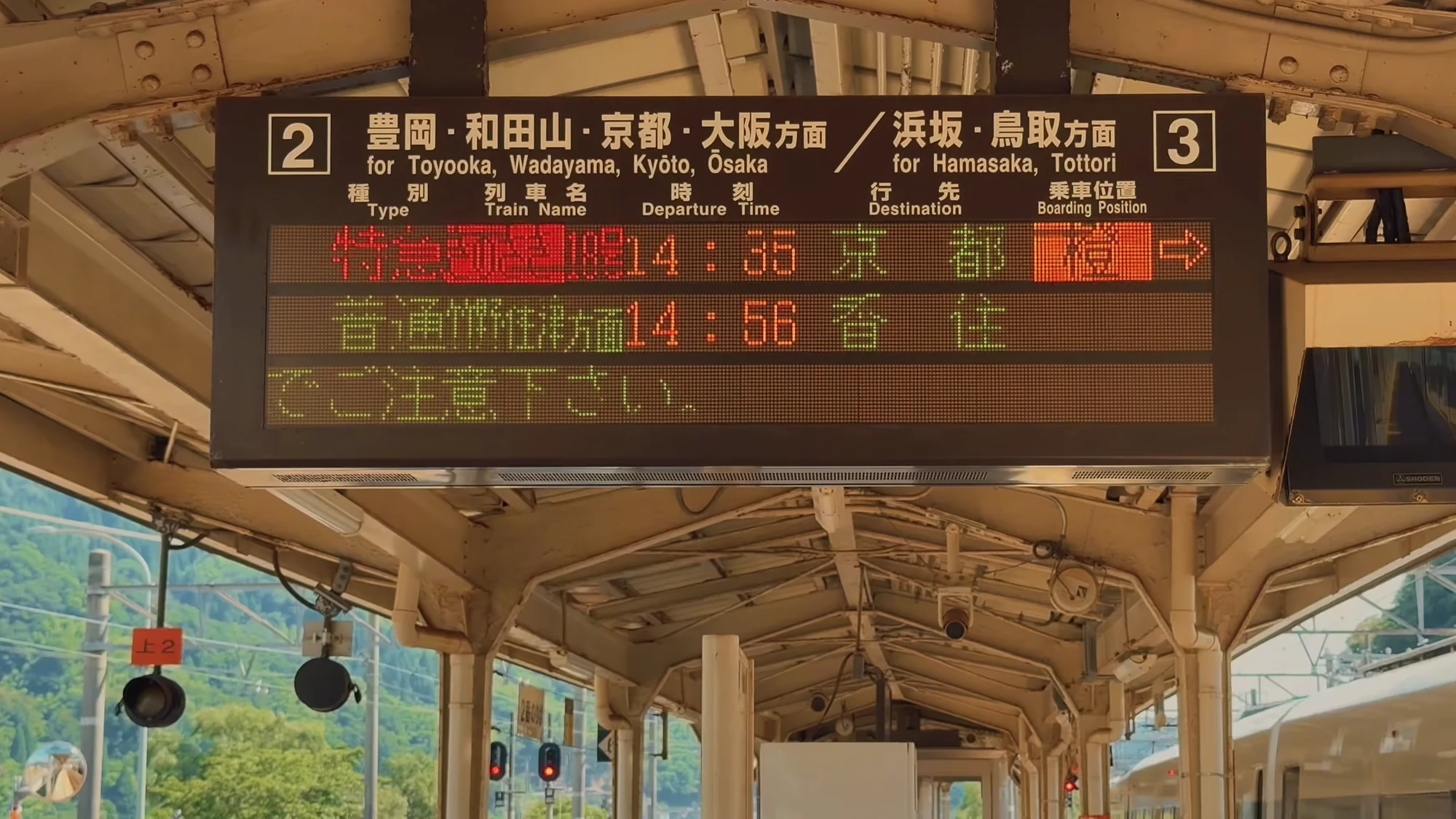 Bilingual platform board at Kinosaki Onsen showing platform 2 for Kyoto and Osaka, platform 3 for Tottori.