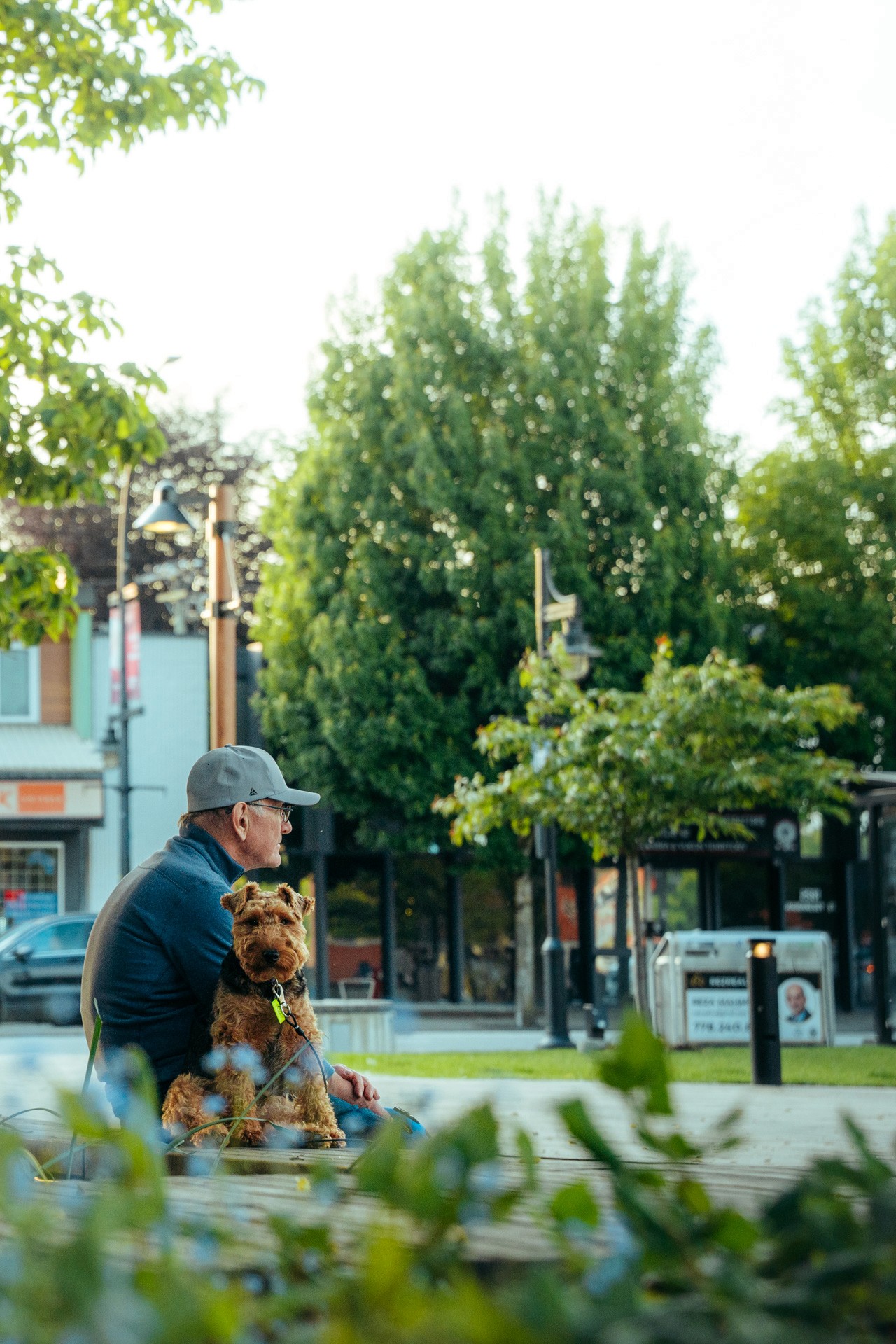 A volleyball player in a black uniform jumping high to spike the ball at the net while opponents attempt to block.