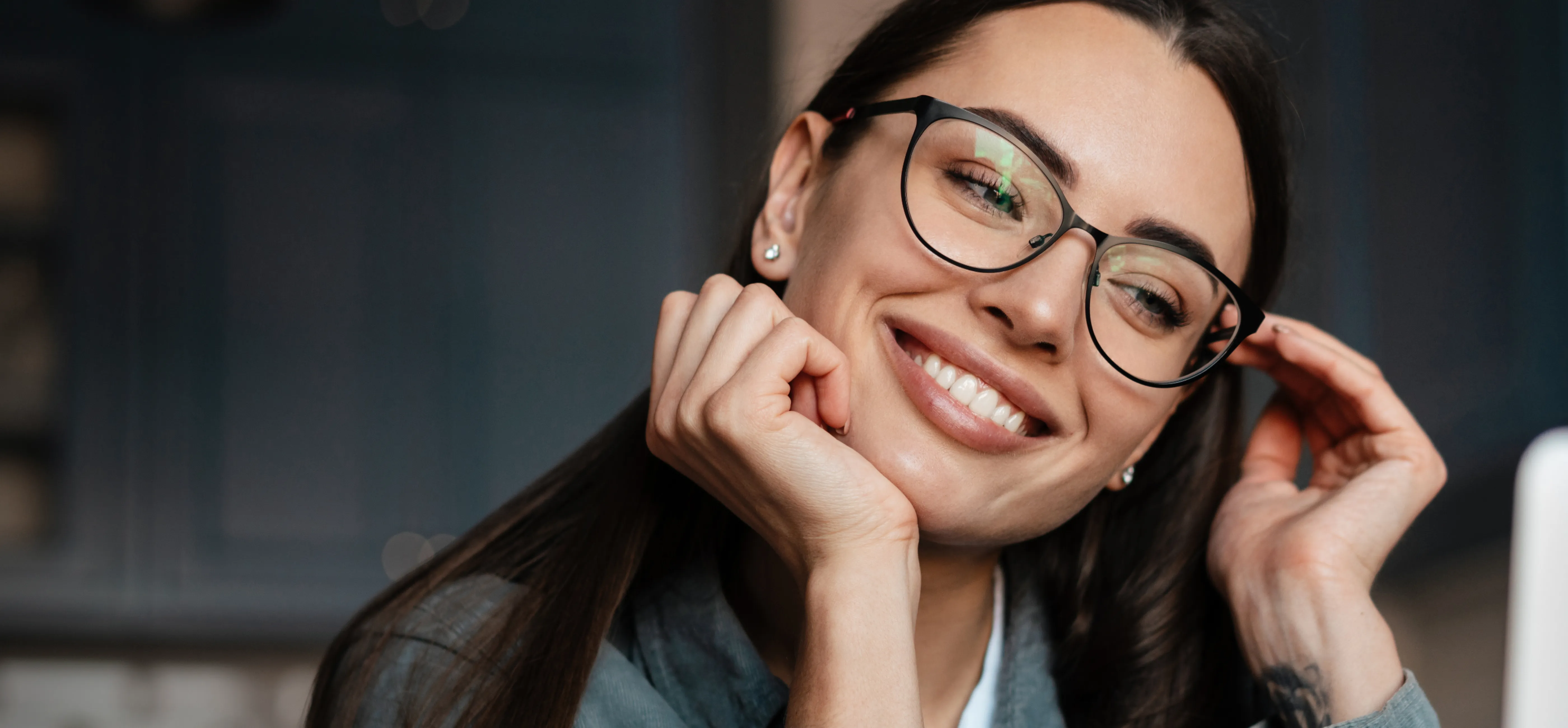 Kobieta z uśmiechem prezentująca efekty bondingu na swoich zębach.