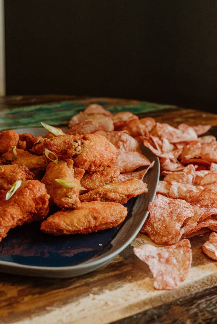 Chicken wings plate with chips on a restaurant table