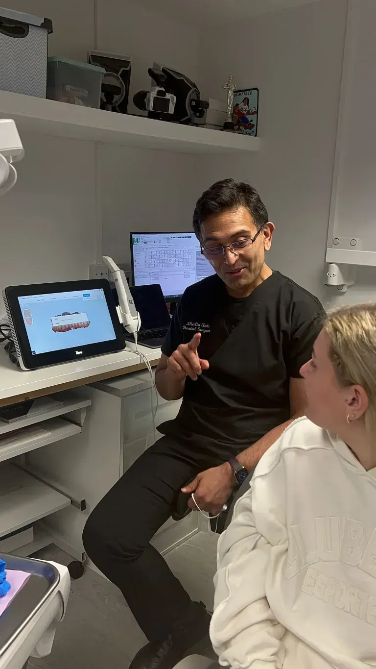 Dr Khalid speaking to a patient about their clear aligners treatment/ invisalign treatment.