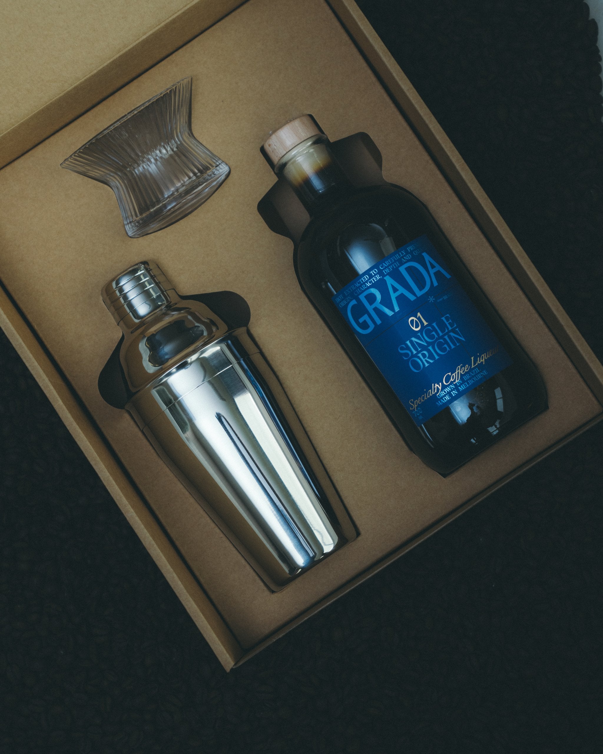 GRADA Gift Box 01 Single Origin — bottle, stainless shaker, hand-blown Japanese coupe and recipe book in branded gift packaging.