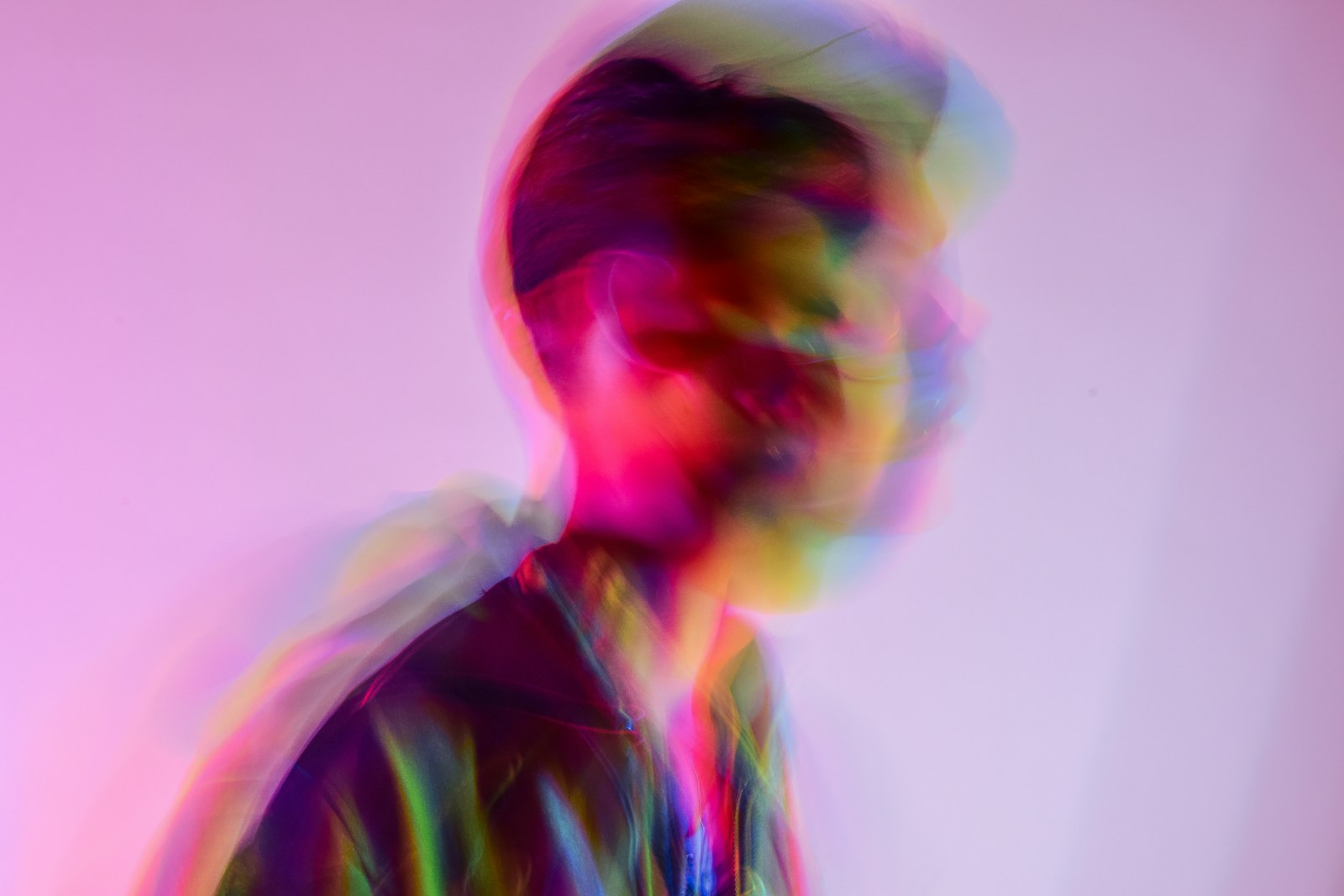 Futuristic motion-blurred portrait lit with iridescent light, evoking a fluid digital-first brand identity