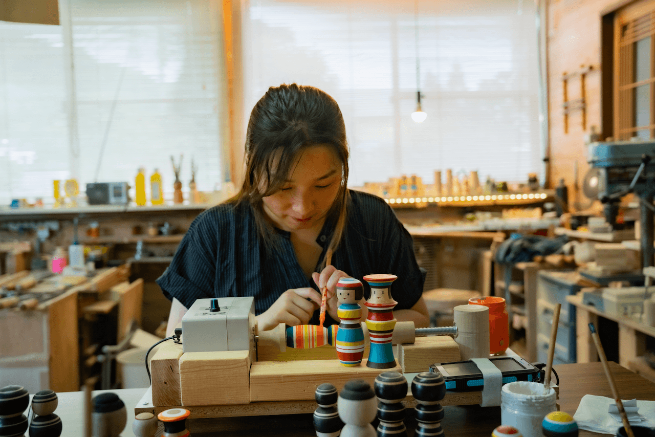Person painting kokeshi doll