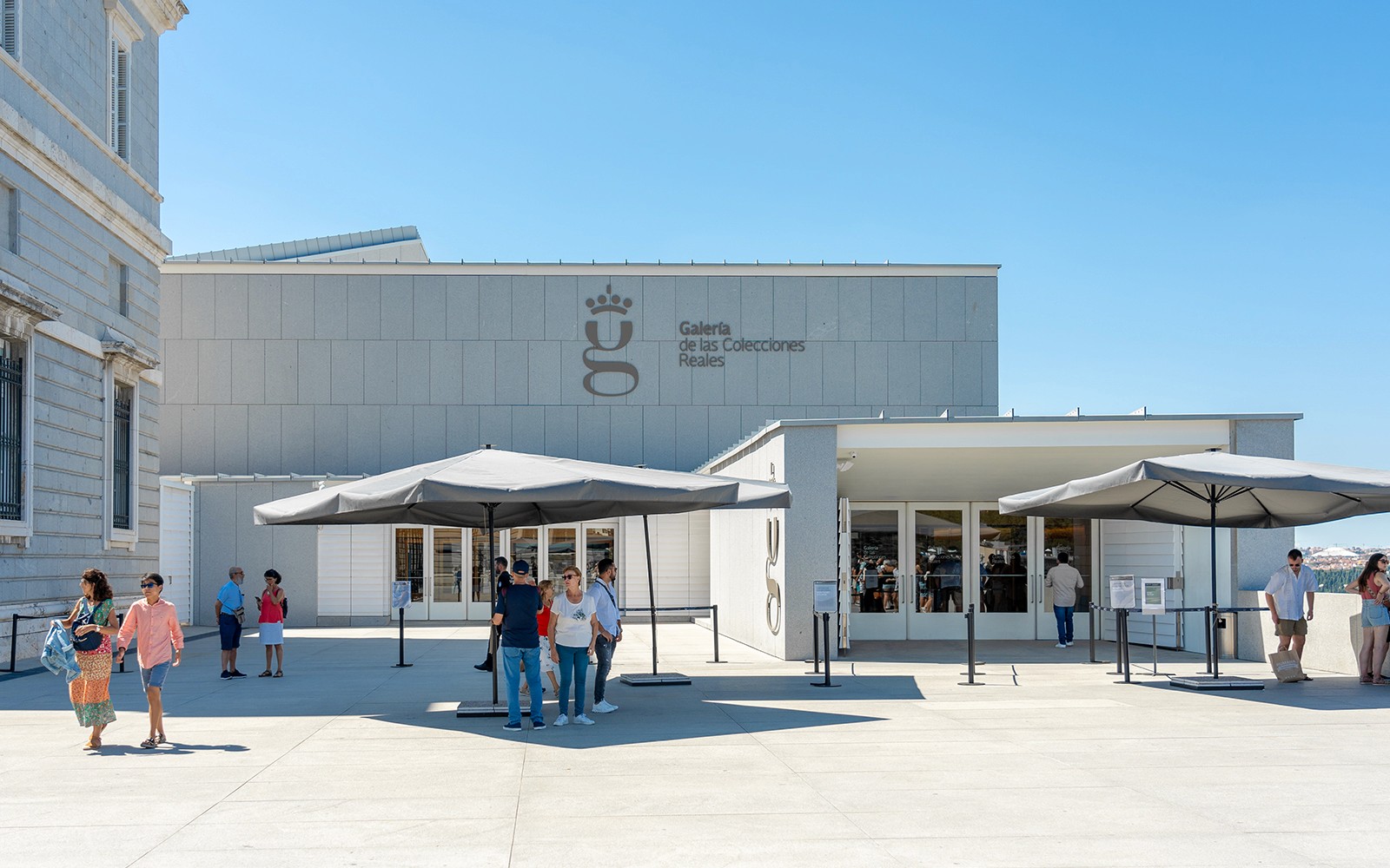Royal Collection Gallery entrance with visitors outside under umbrellas.