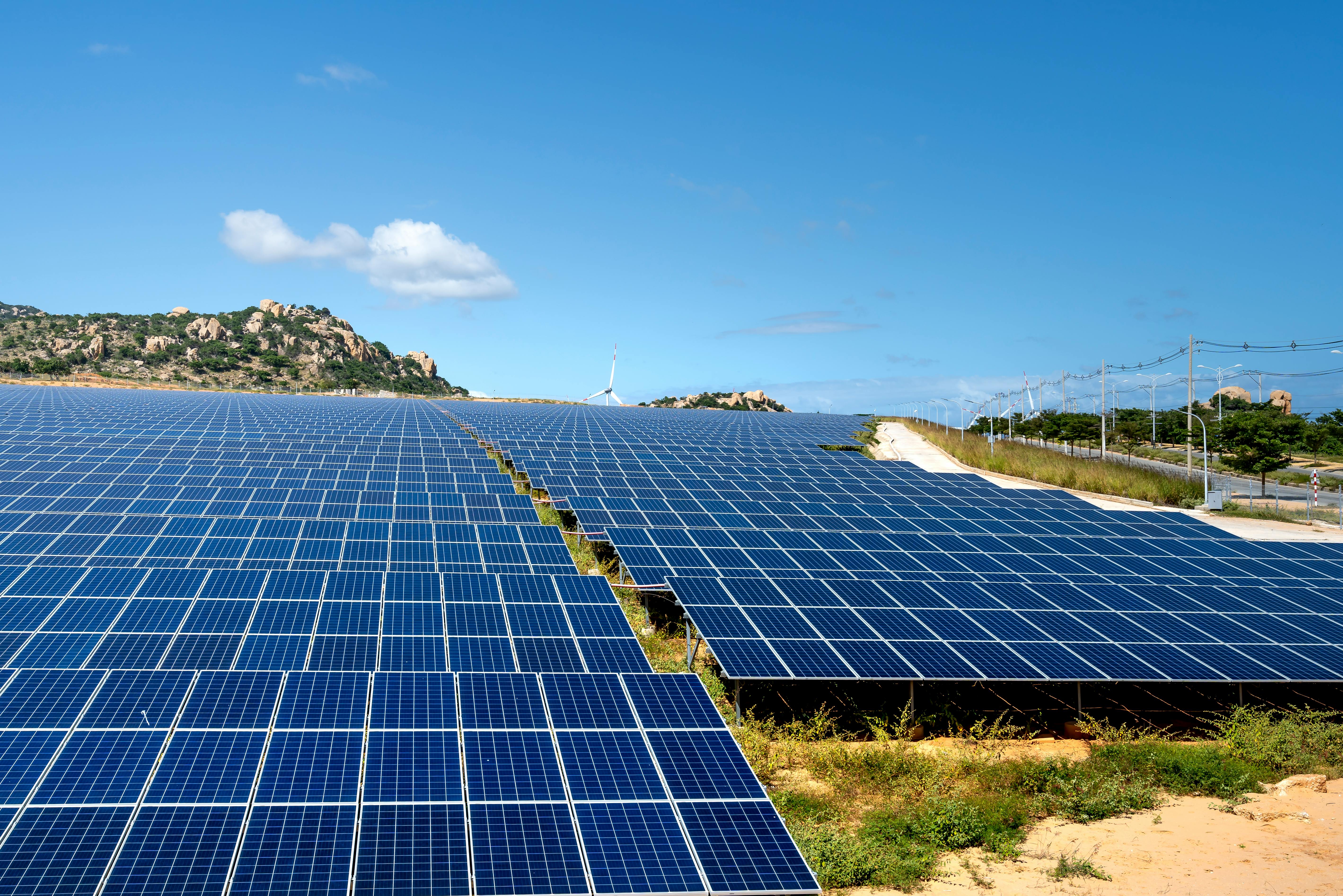 Vast solar farm with rolling hills and blue sky