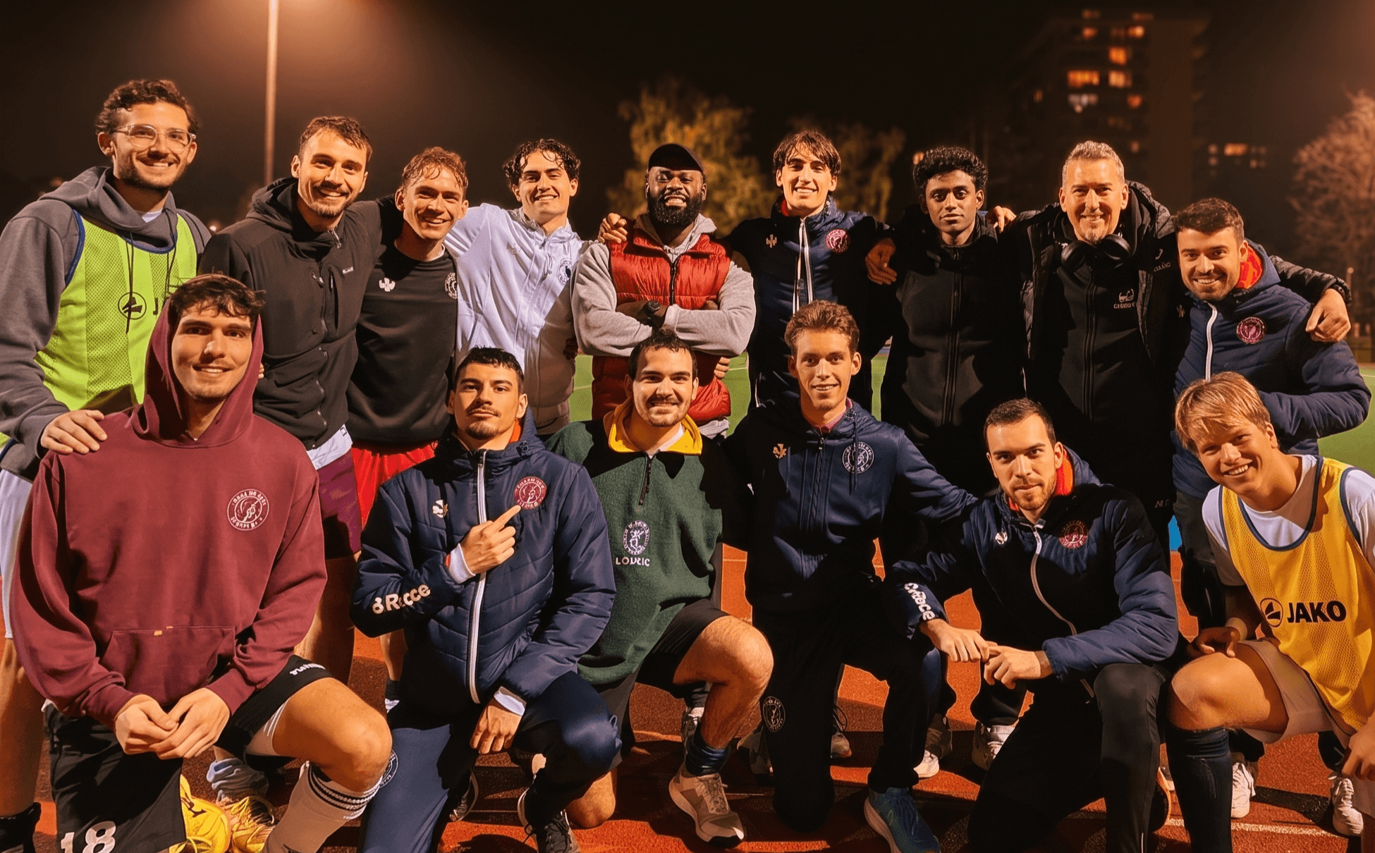 Dimkpa Chujor with a group of athletes after an evening training session on an outdoor track in Geneva.
