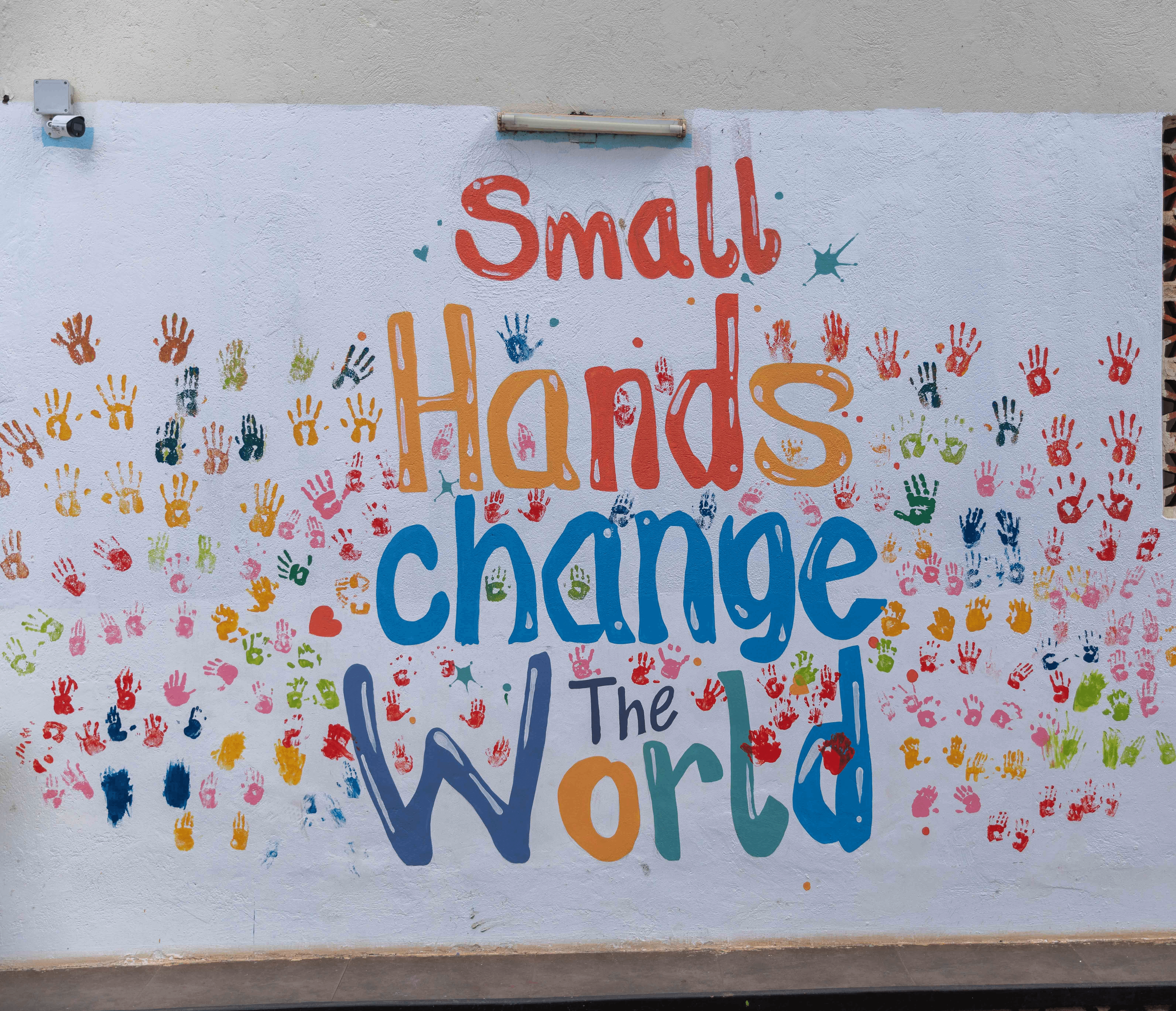 A teacher stands in the middle of the classroom between the desks